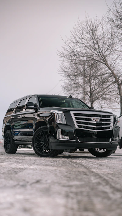 A black cadillac parked in a parking lot