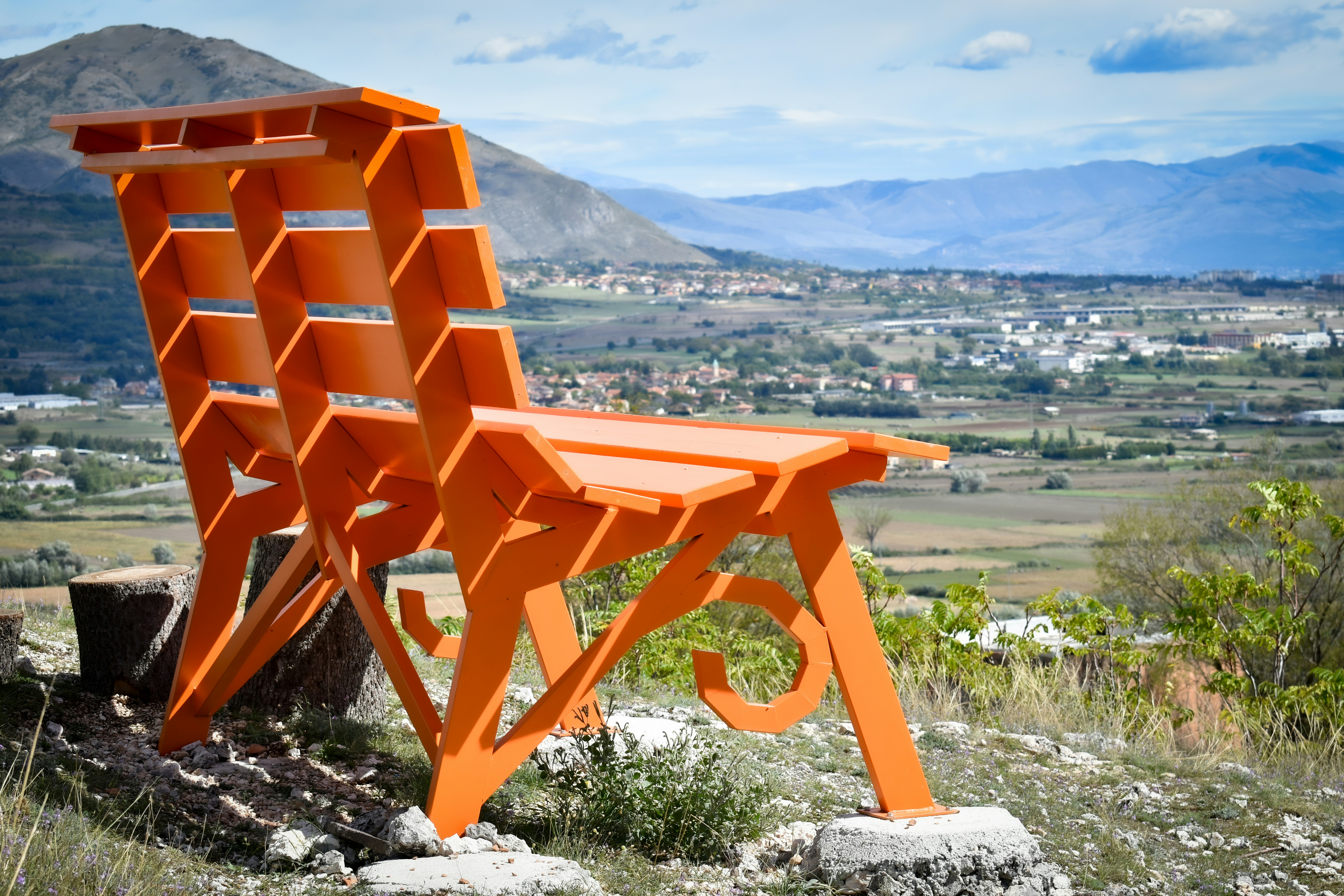 An orange chair sitting on top of a hill