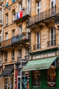 A building with a green awning next to a street