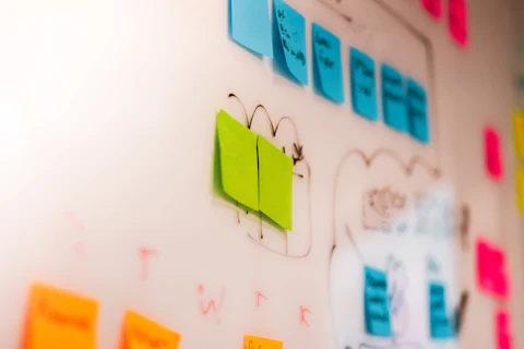 A cluttered wall covered in dozens of overlapping colorful sticky notes