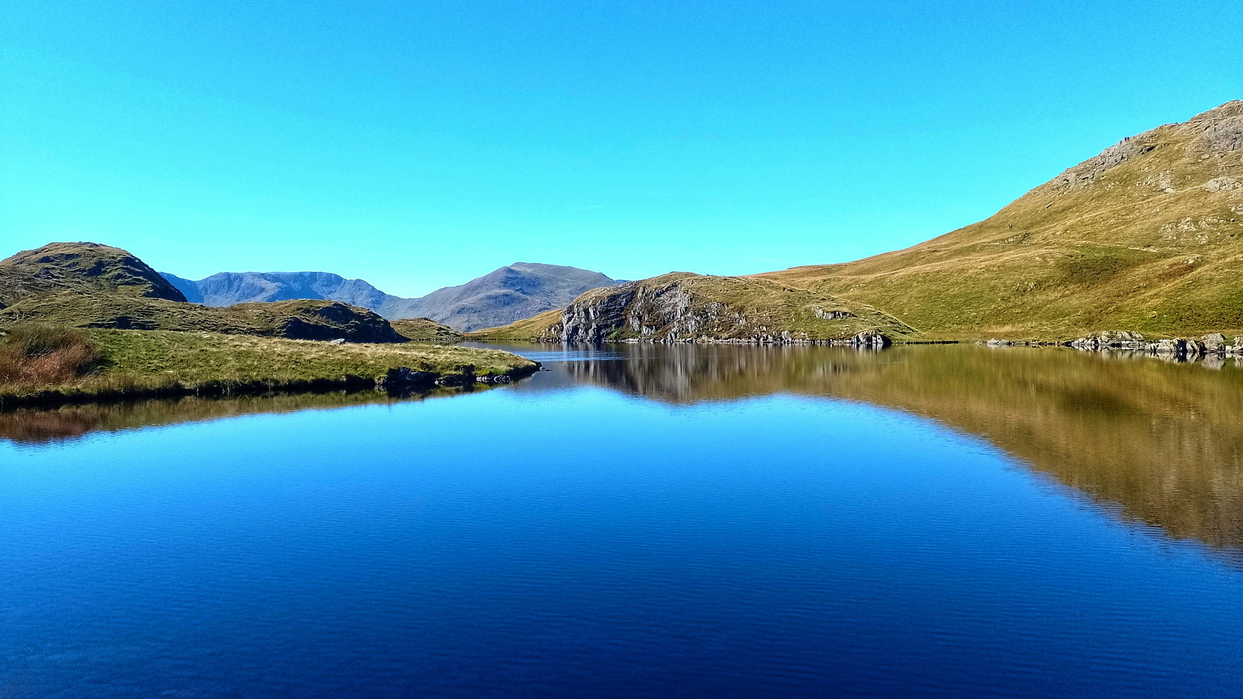 a-large-body-of-water-surrounded-by-mountains-photo-free-angle-tarn