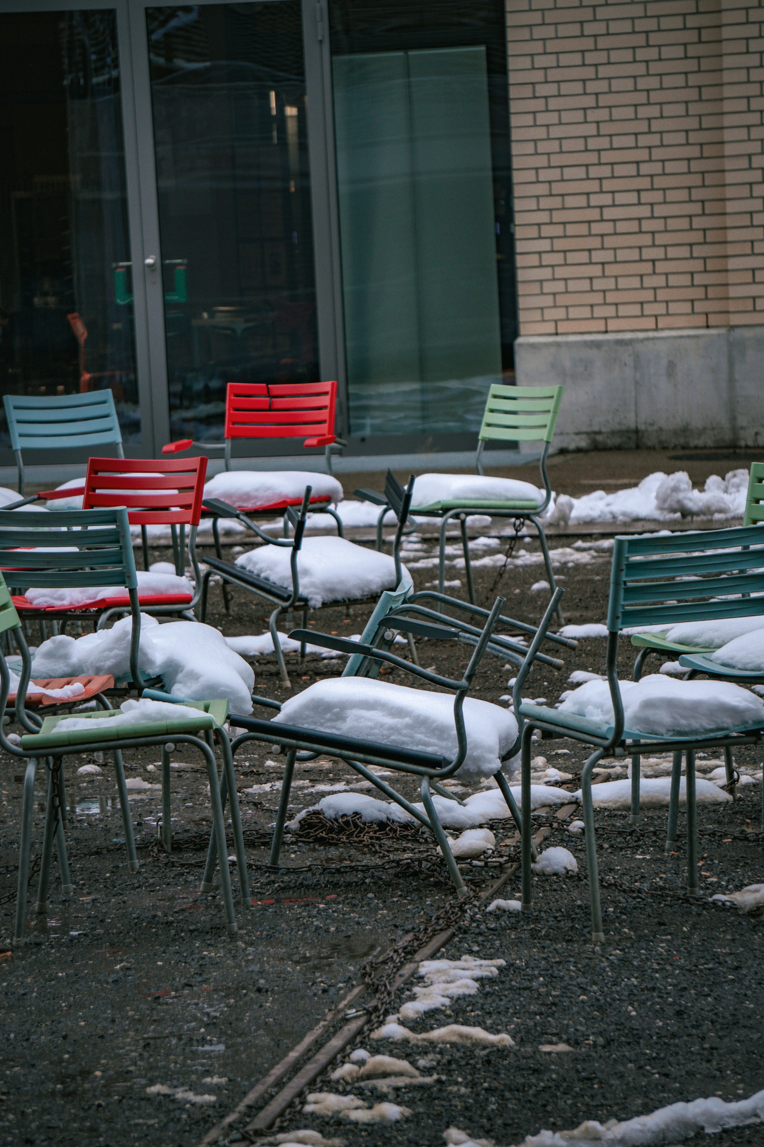 Un tas de chaises qui sont assises dans la neige