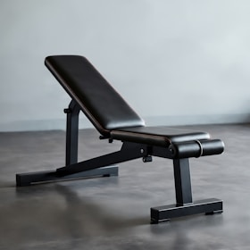 A black bench sitting on top of a gray floor
