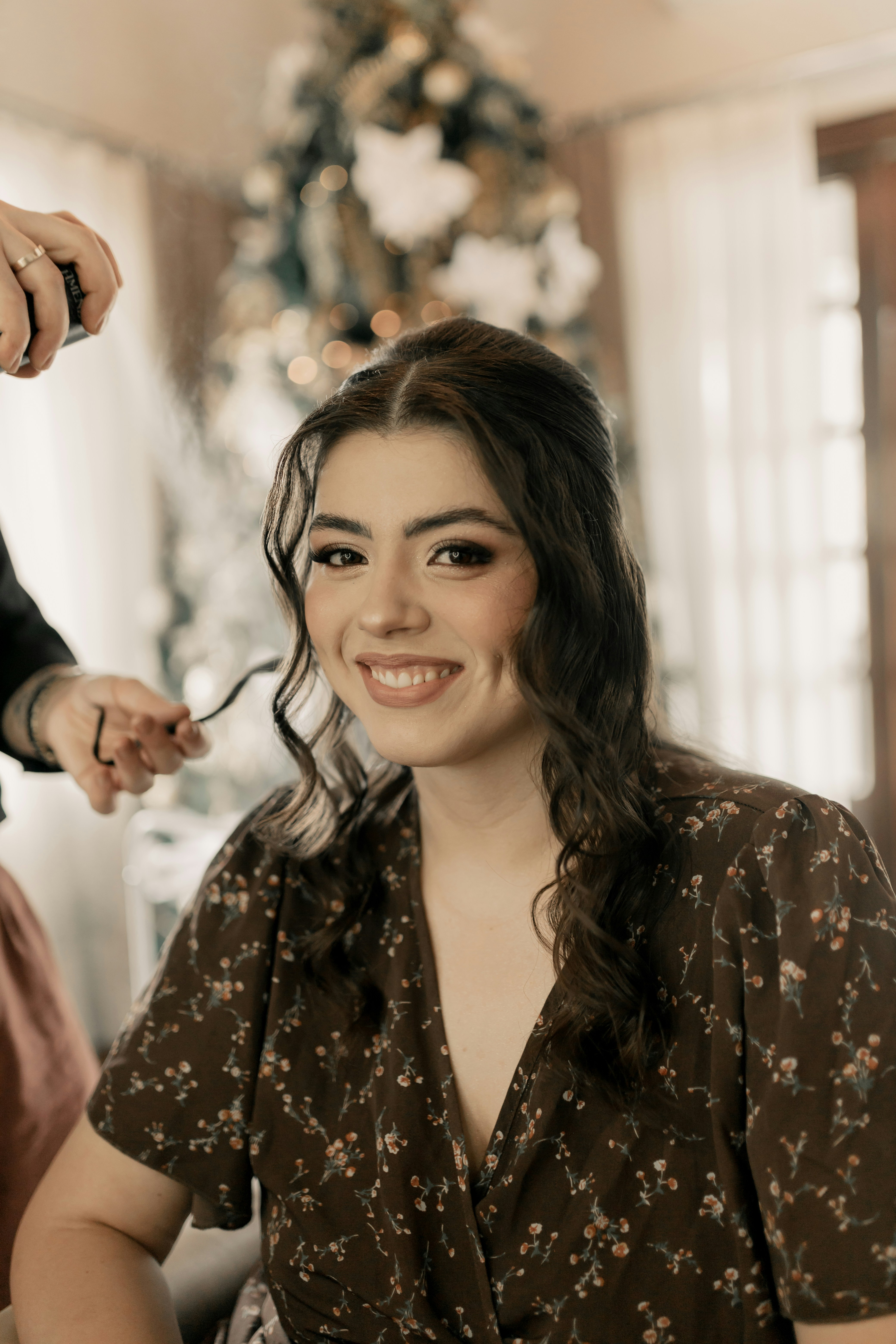 Mujer joven con cabello oscuro largo y sonrisa cálida, iluminación suave de estudio fotográfico