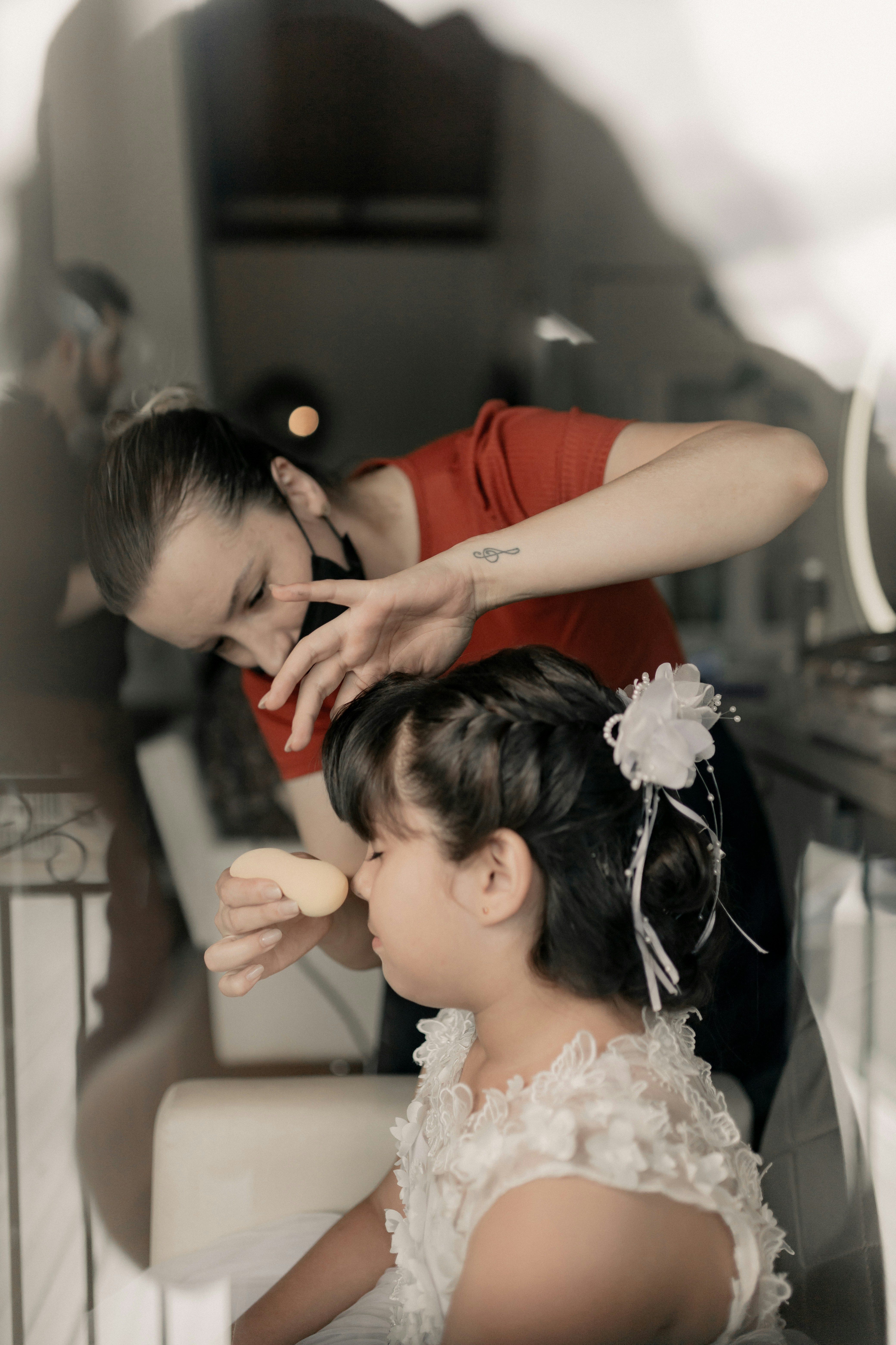 A woman helping a little girl brush her hair