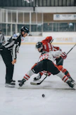 A group of people playing a game of ice hockey