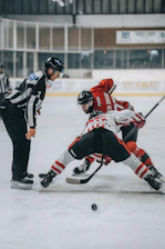 A group of people playing a game of ice hockey