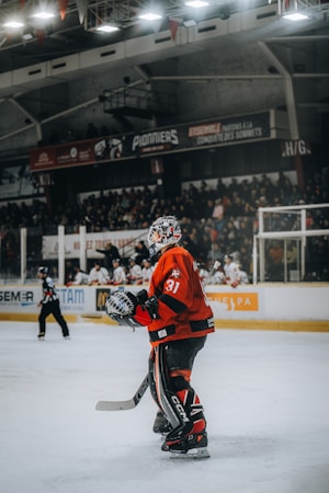 A hockey player in a red jersey on the ice during a game, representing the on-ice action fans will see during Season X theme nights