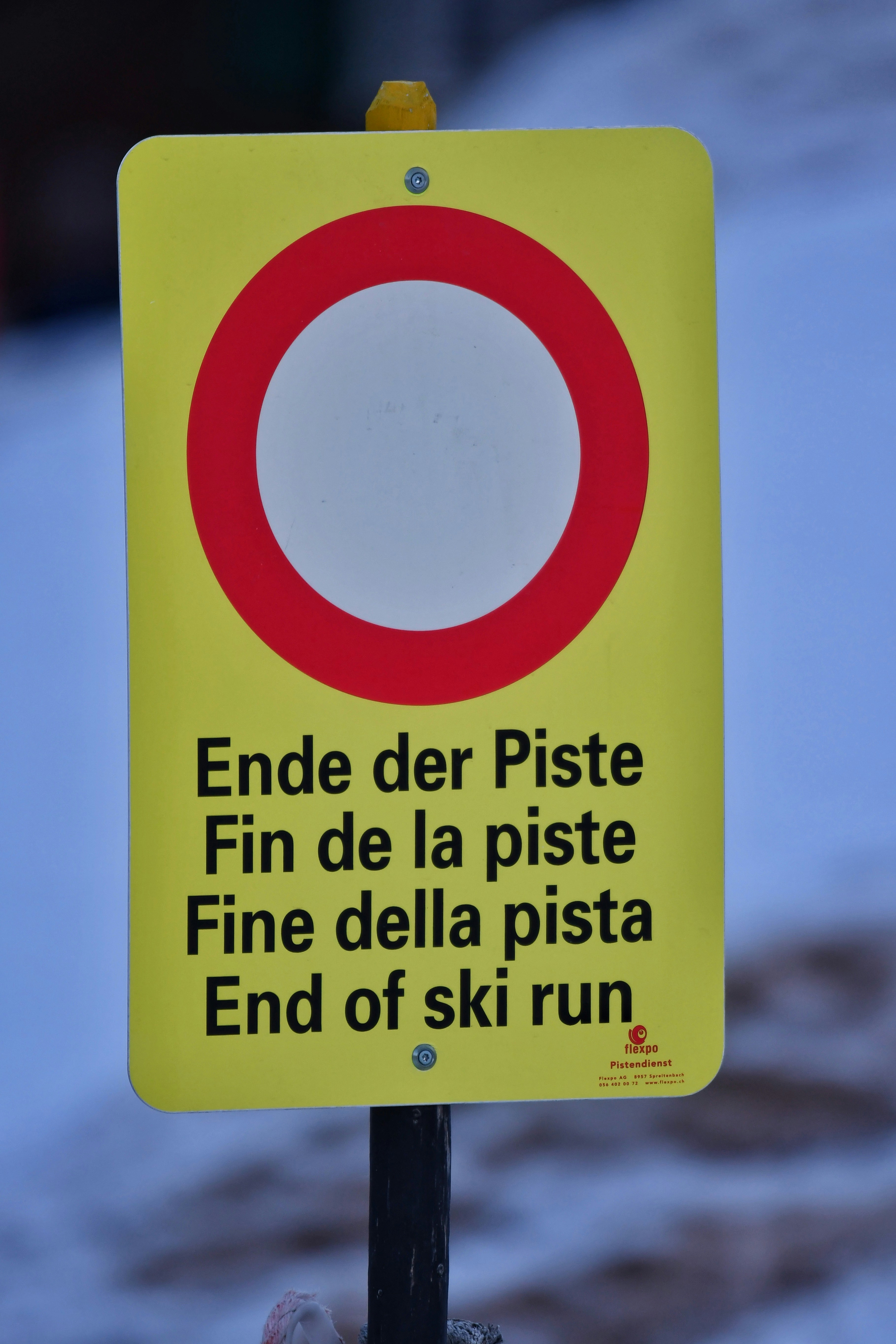 A yellow sign that says end of ski run