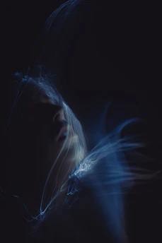 A blurry photo of a woman's face in the dark