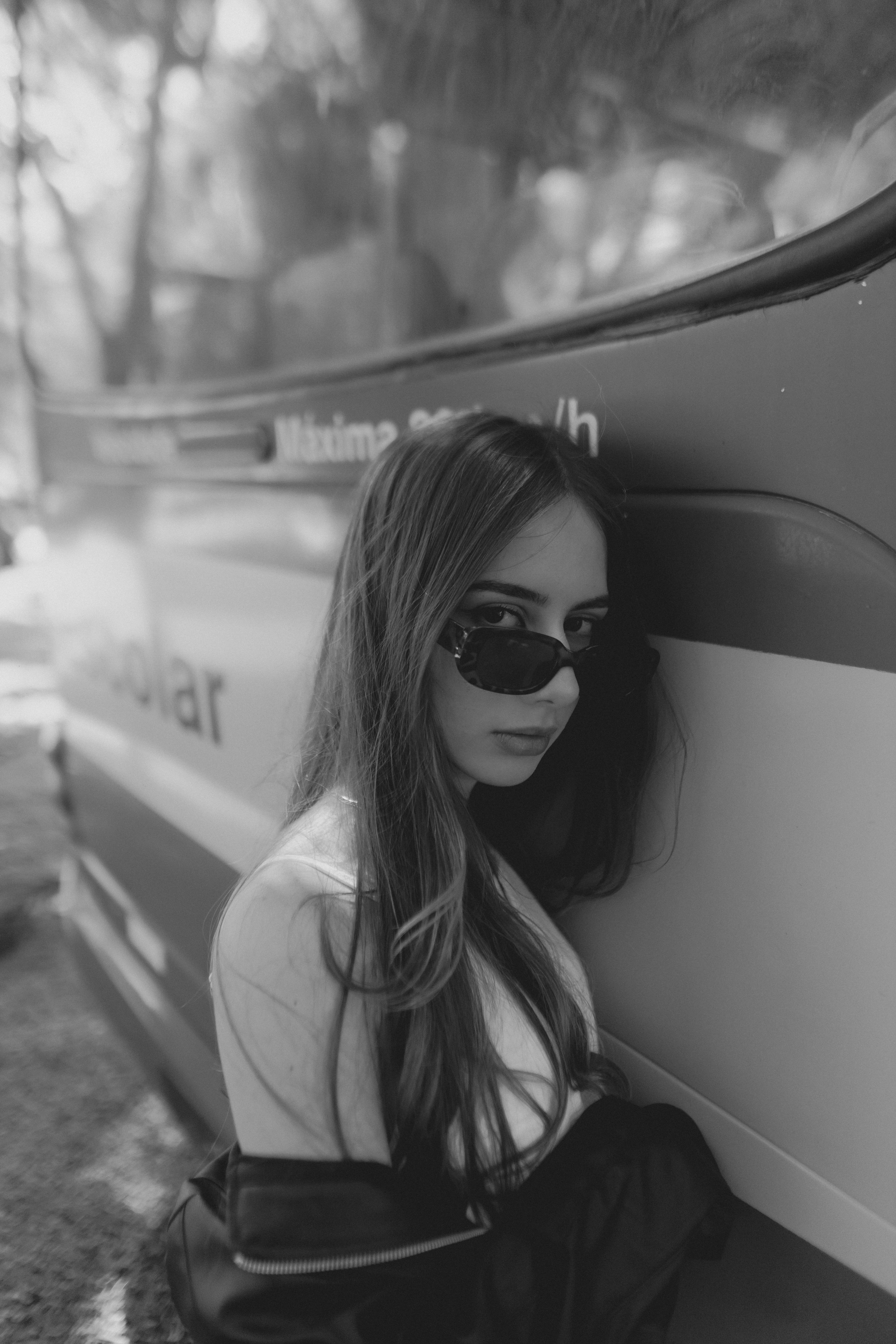 A woman sitting on the side of a bus