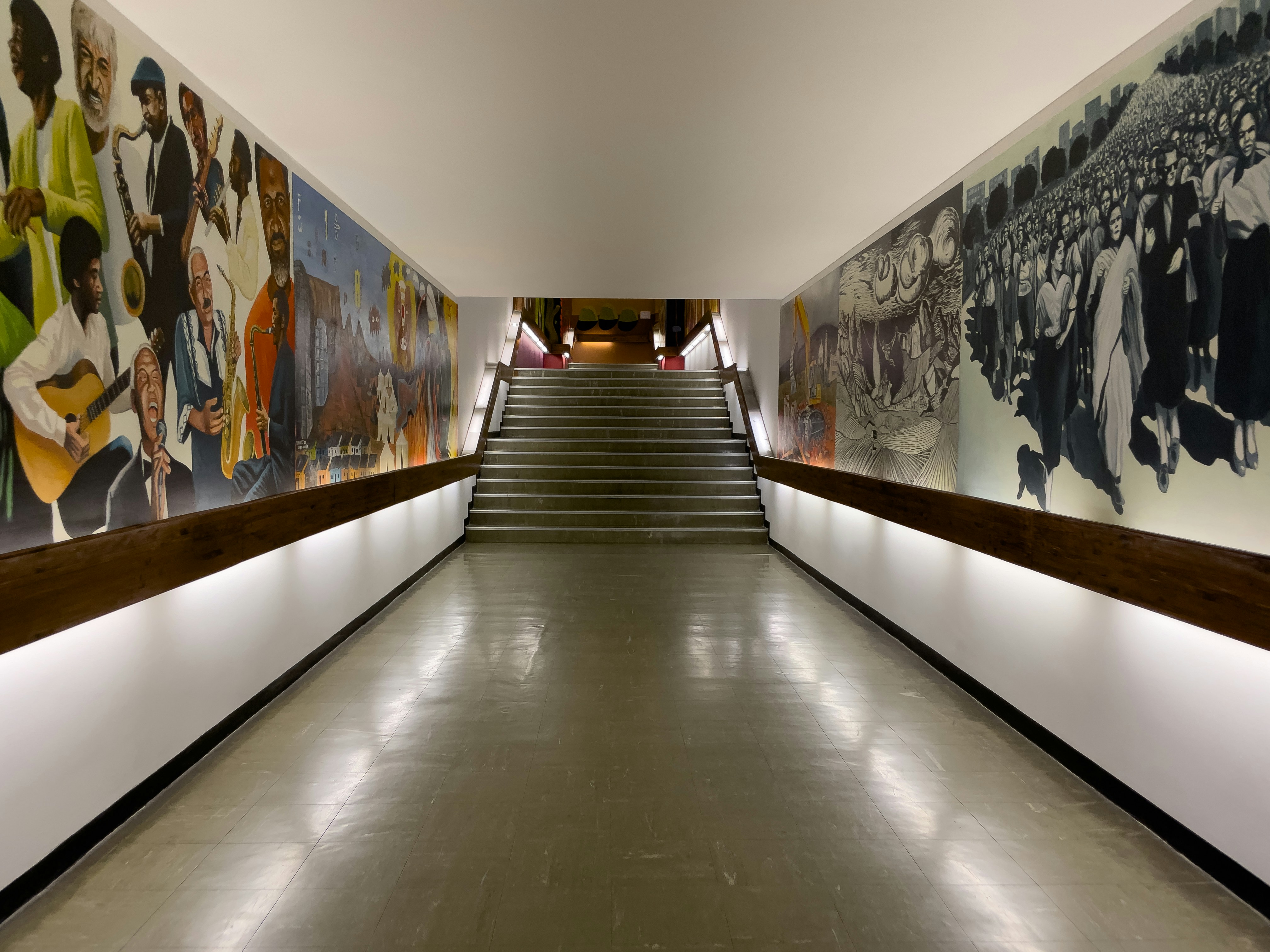 A long hallway with a lot of paintings on the wall