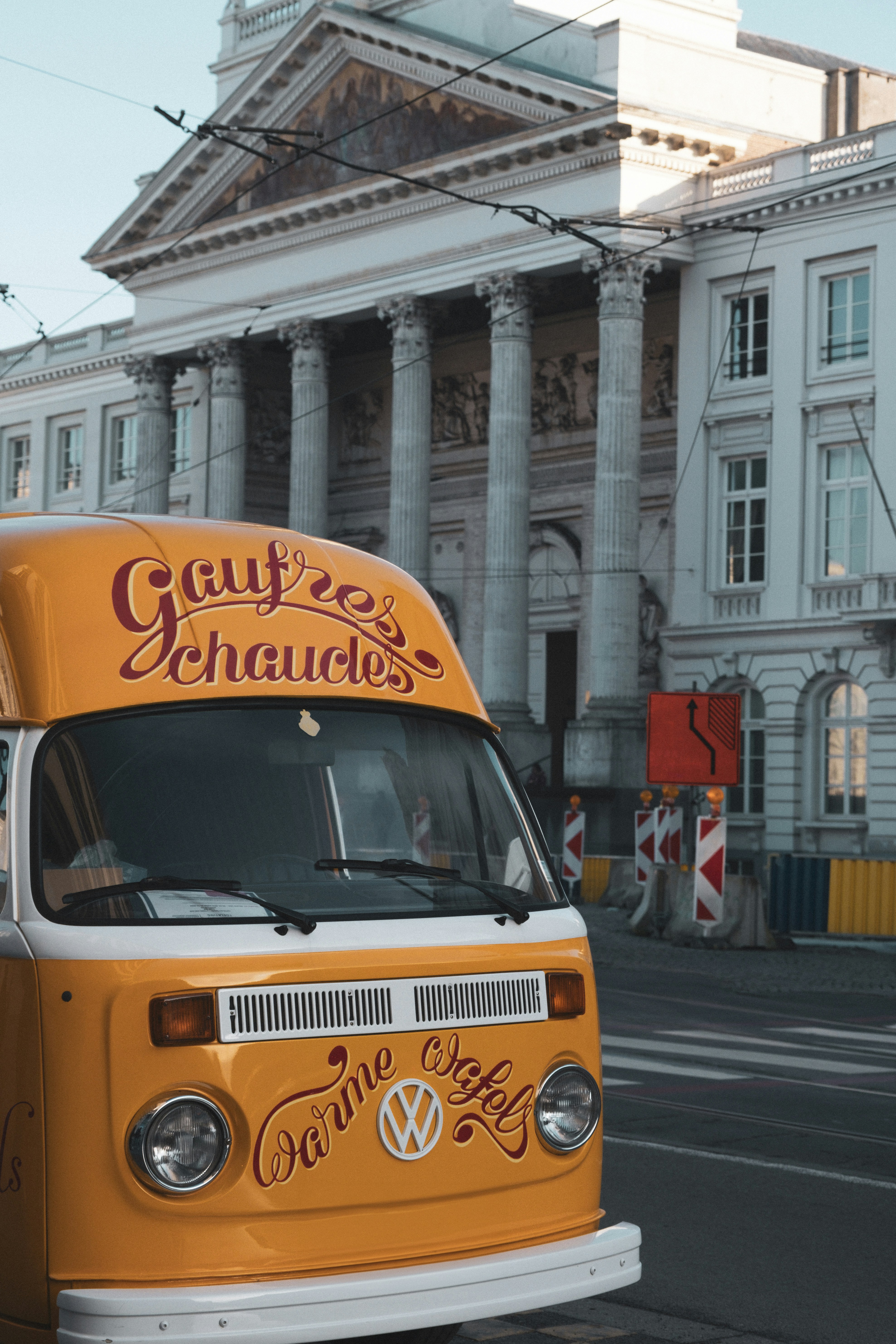 A yellow van is parked in front of a building
