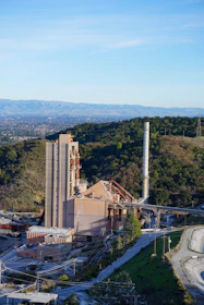 An aerial view of a factory with mountains in the background