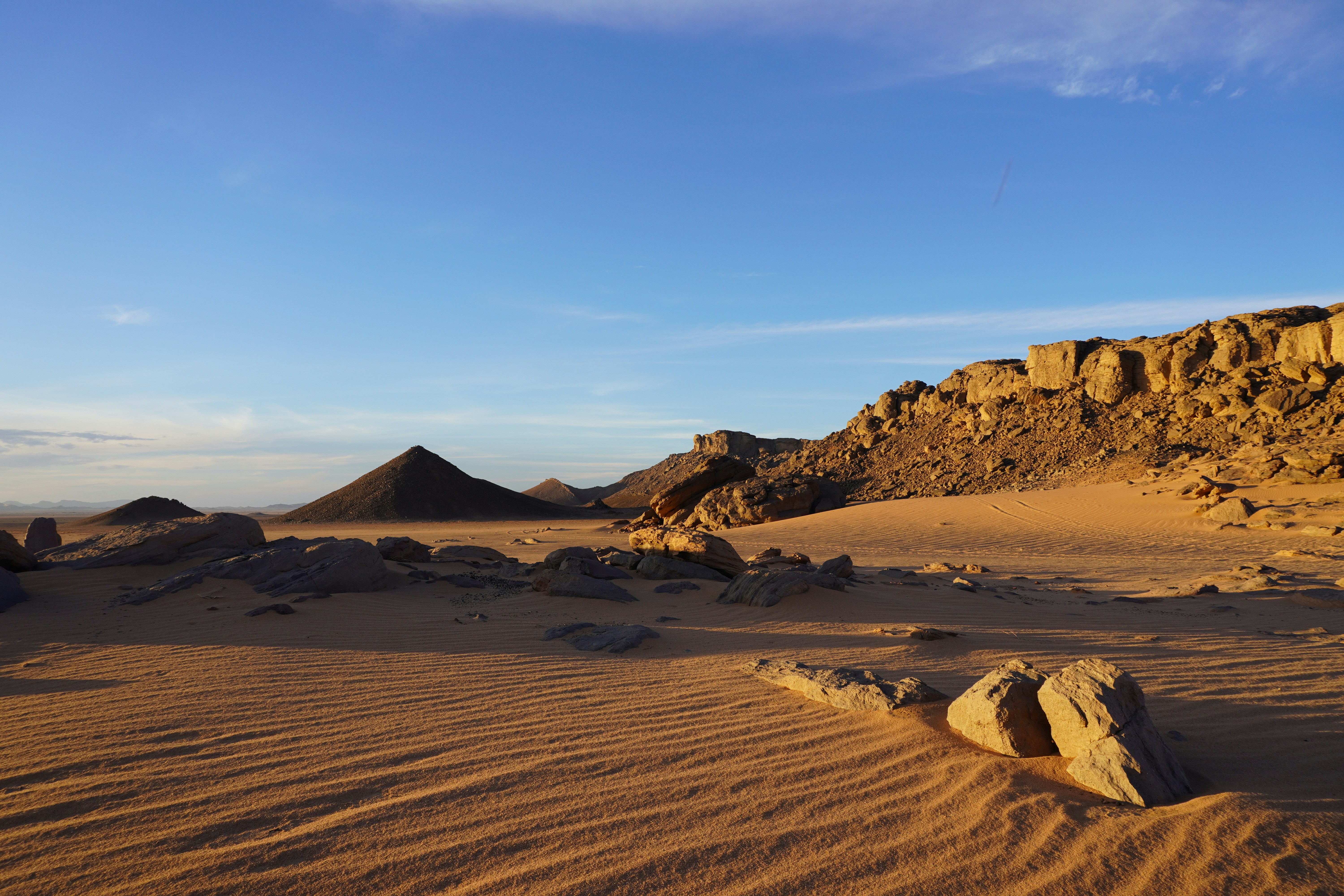 A desert landscape with a rock formation in the foreground