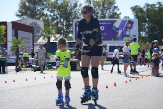 A woman riding a skateboard next to a little girl on a skateboard