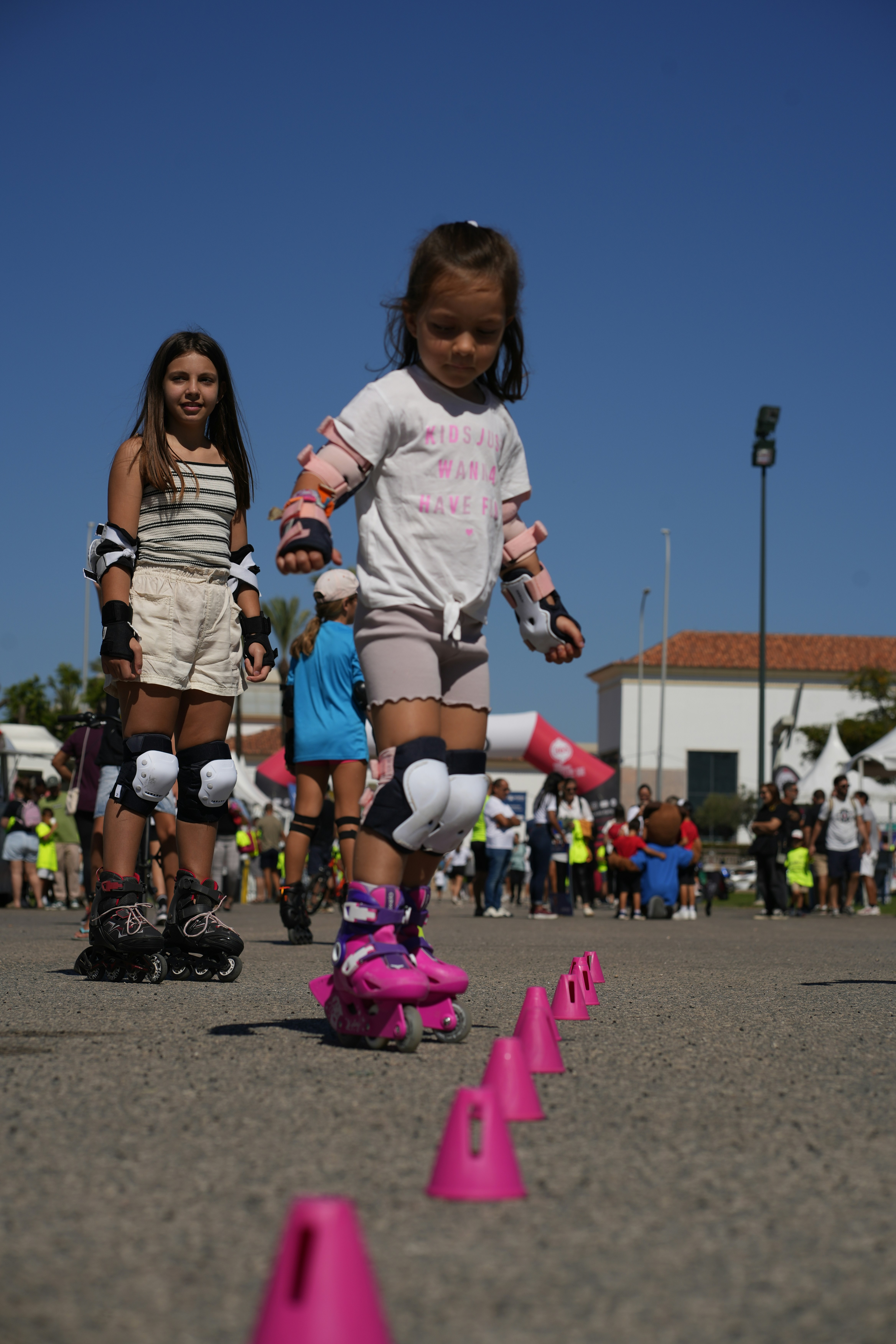 A group of young girls riding skateboards down a street