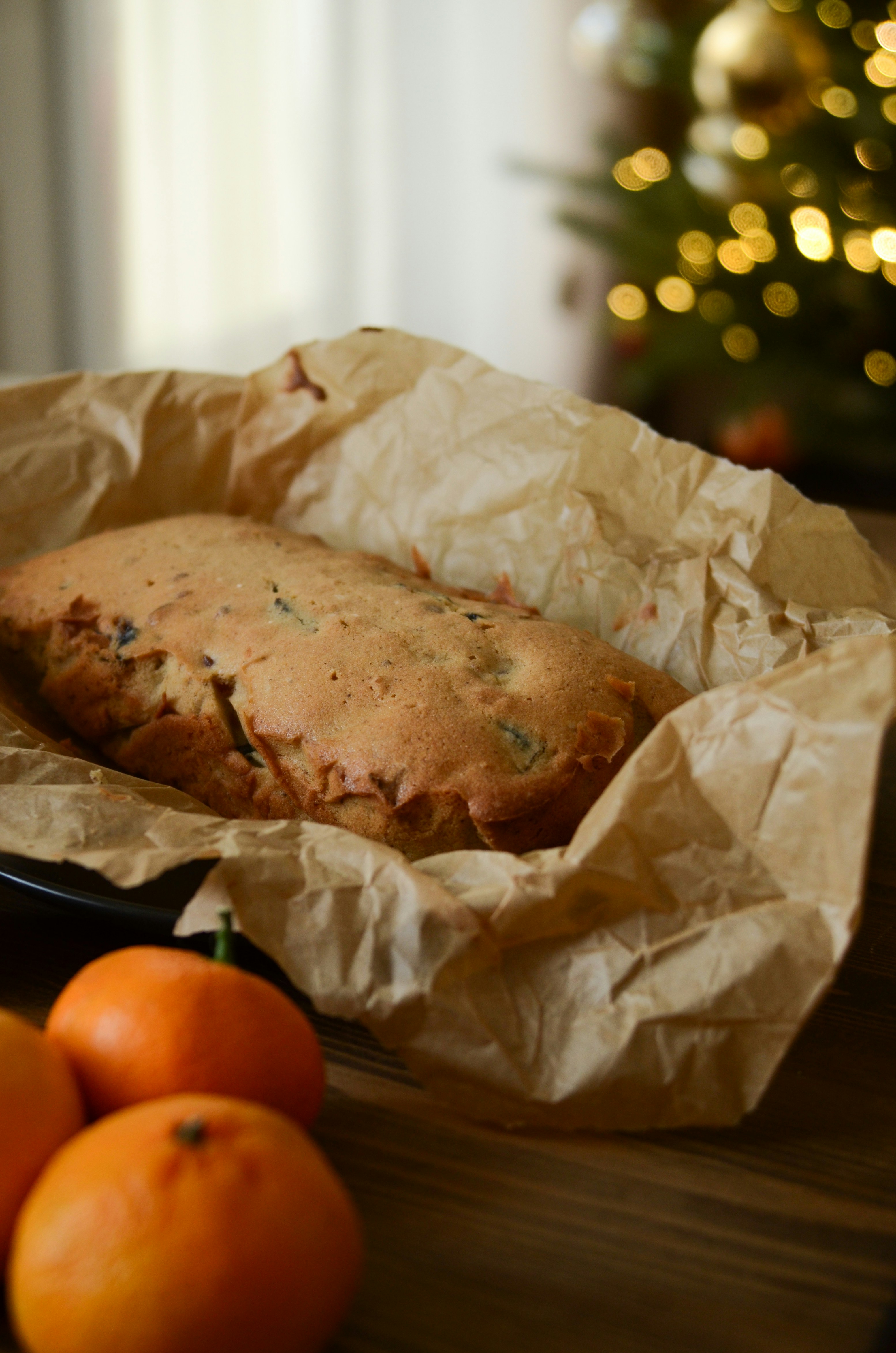 A loaf of bread sitting on top of a table next to oranges