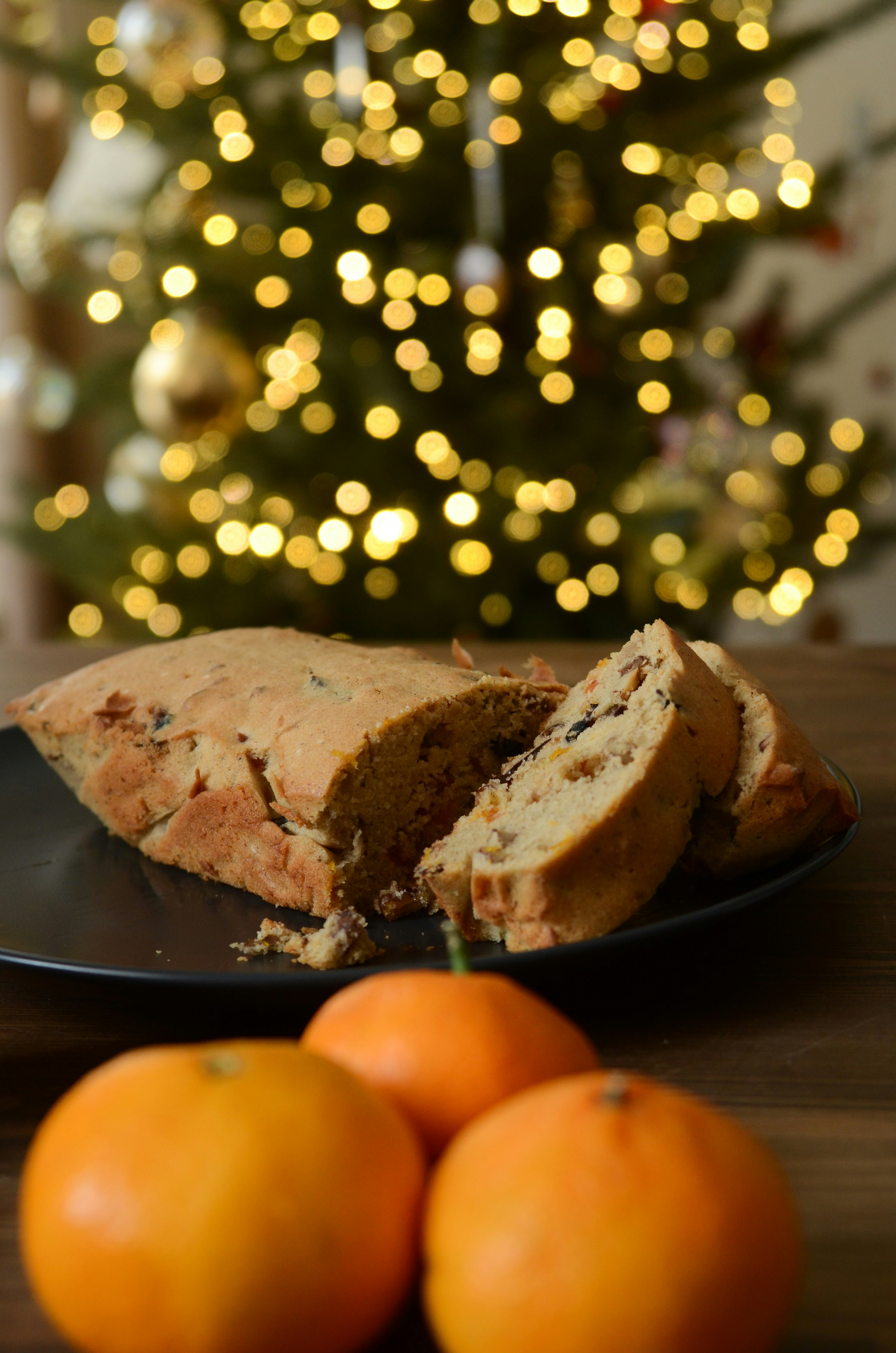 A plate with a piece of cake on it next to some oranges