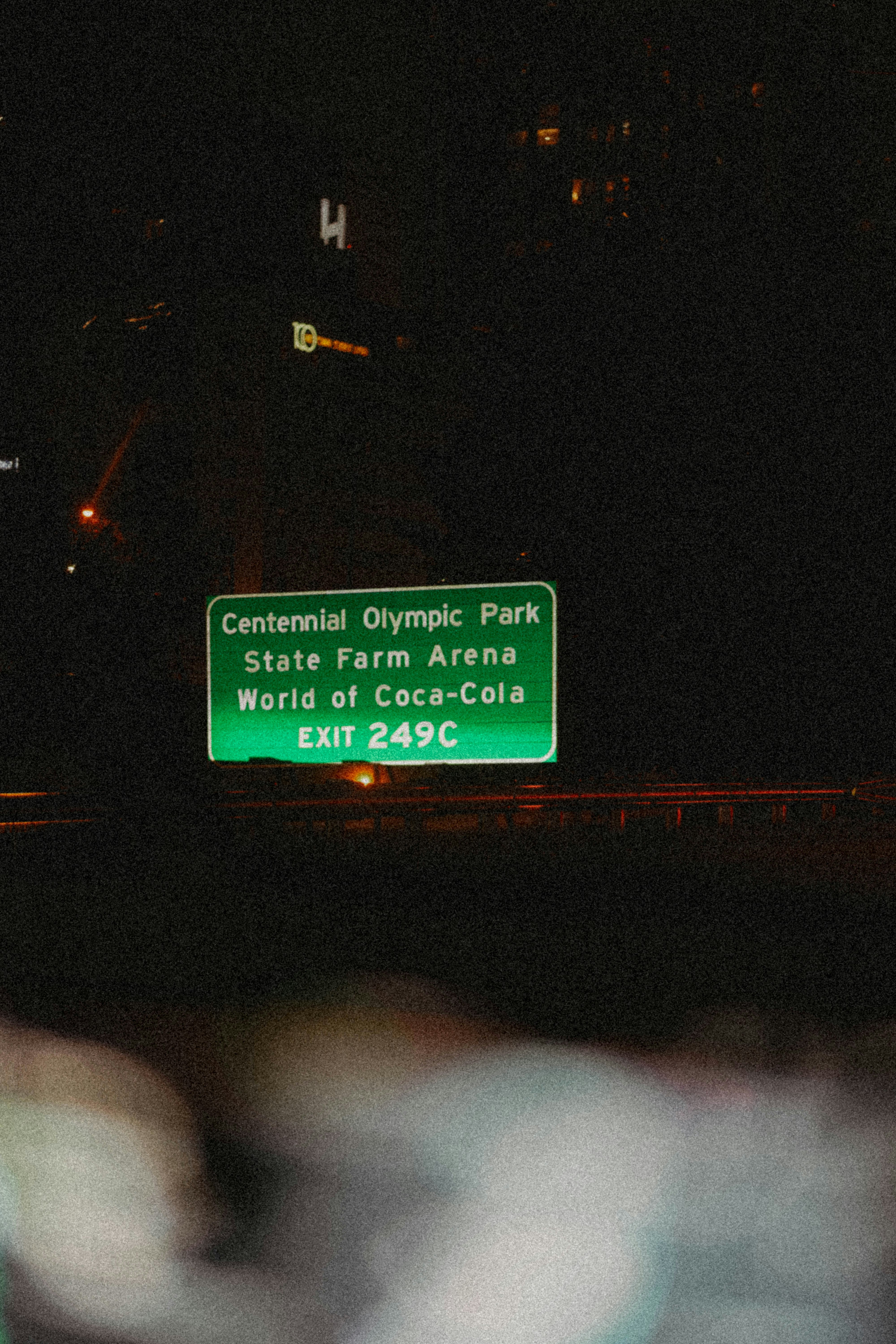 A green street sign sitting on the side of a road