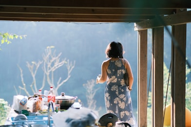 A woman standing in a doorway looking out into a yard