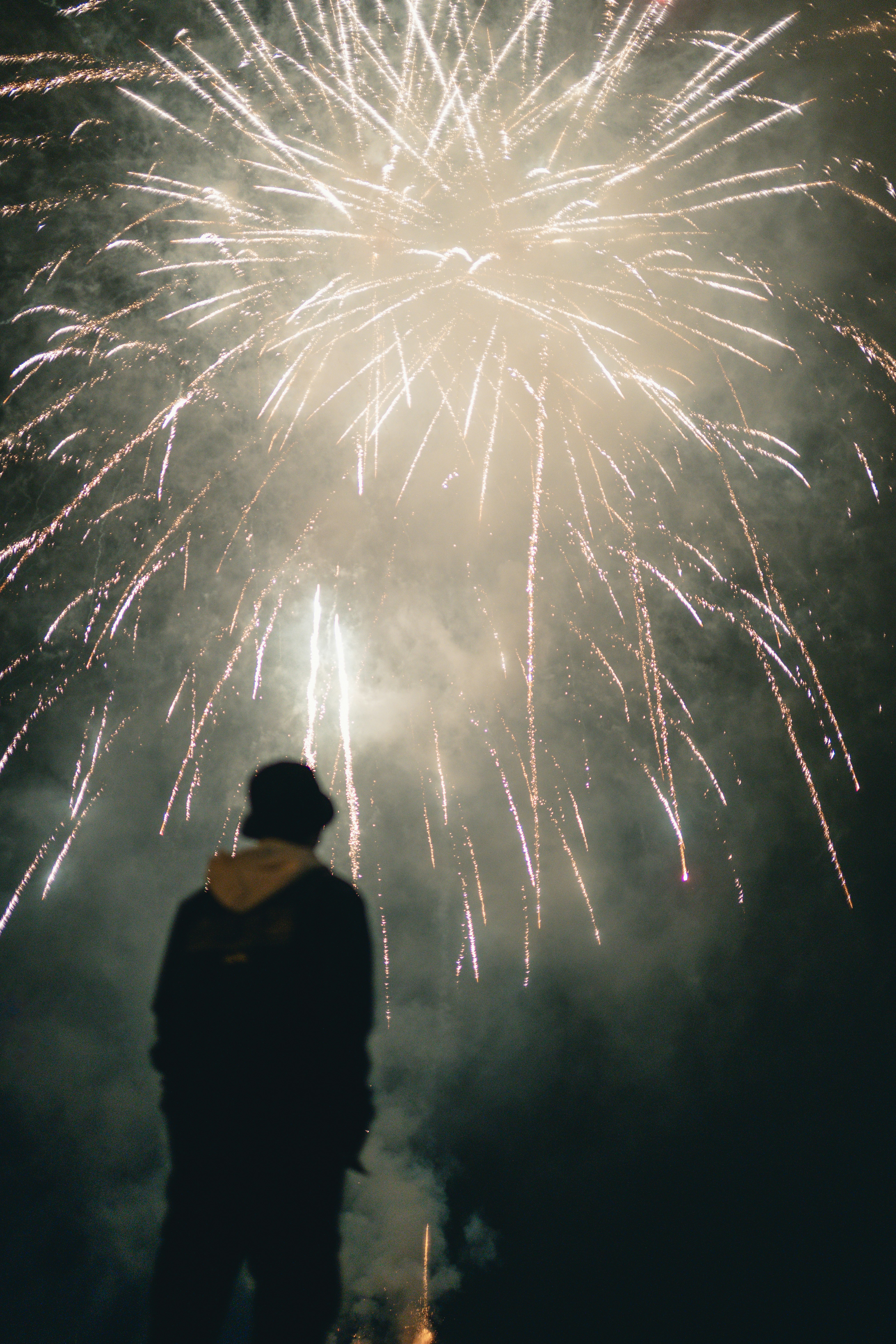 A person standing in front of a fireworks display photo – Free ...