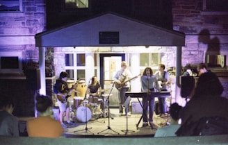 A band performs live music outdoors at night.