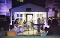 A band performs live music outdoors at night
