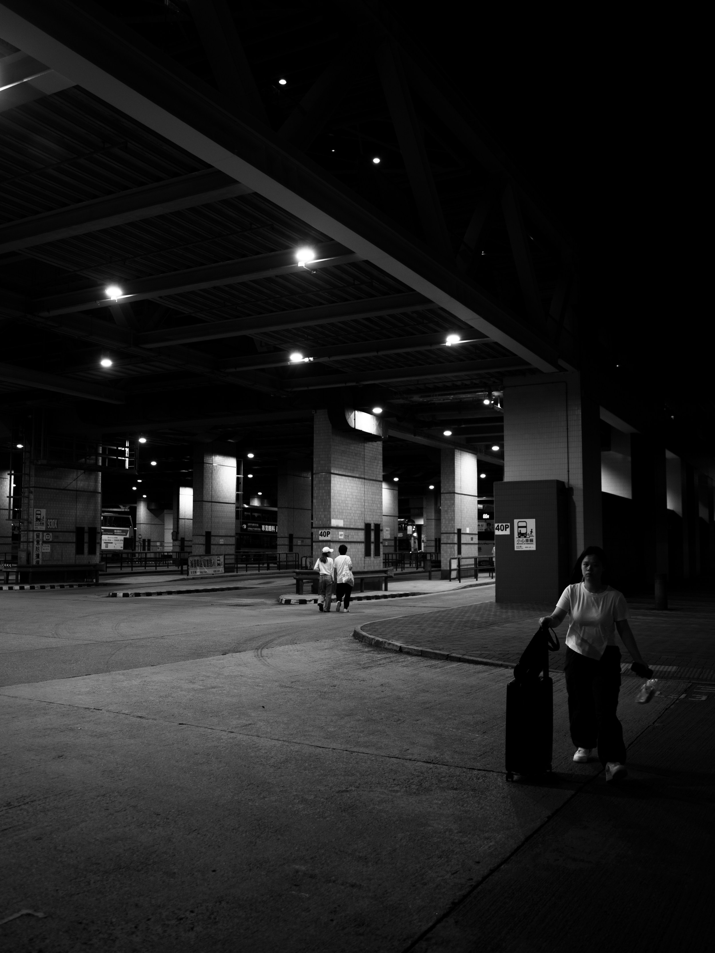 A person sitting on a skateboard in a parking lot