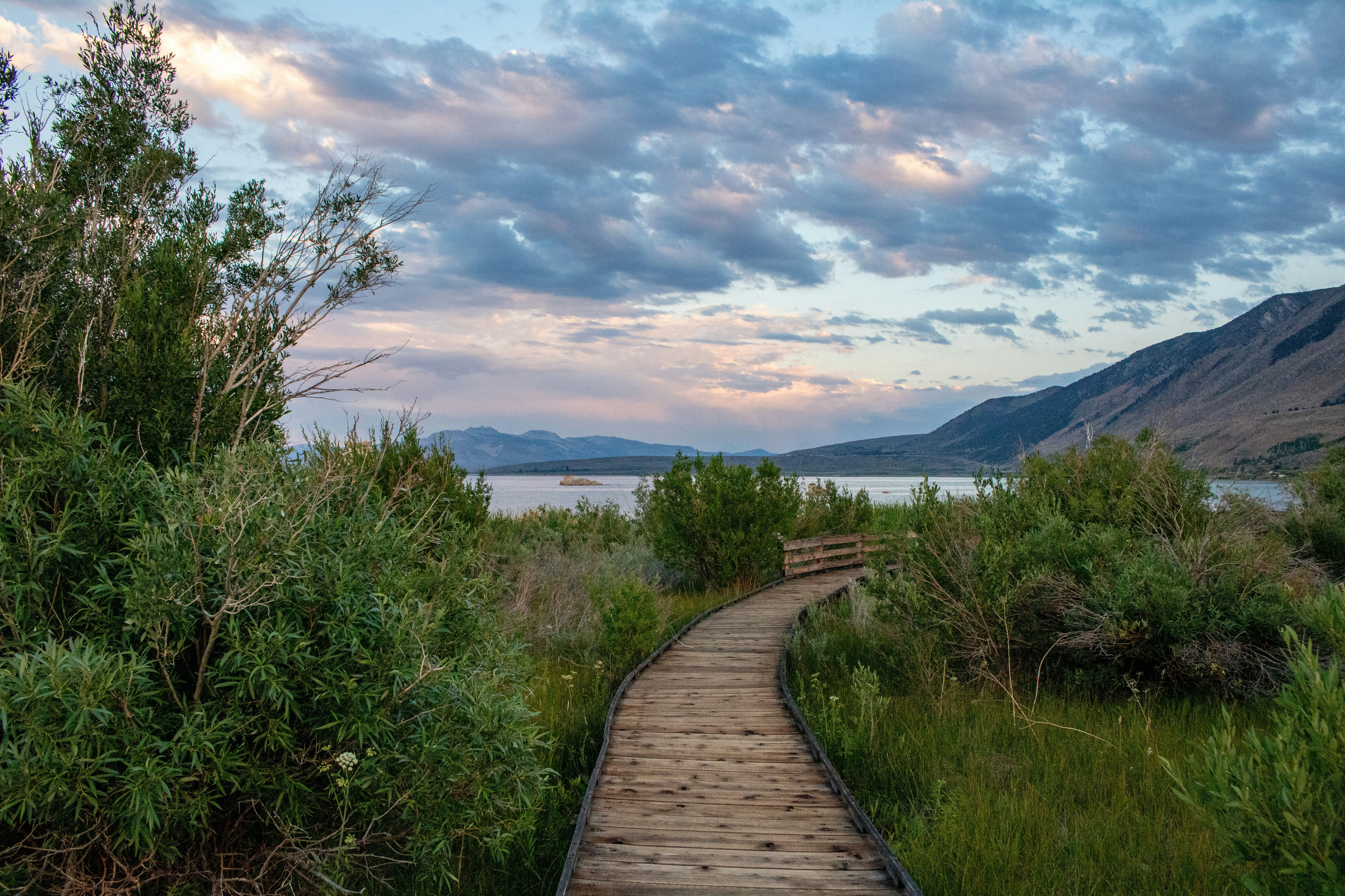 The Mono Lake Boardwalk offers visitors a unique way to explore the natural beauty of Mono Lake in California’s Eastern Sierra. This wooden pathway winds through marshlands and sagebrush, leading to the lake’s edge while protecting the fragile ecosystem. Along the way, visitors can observe breathtaking views of the ancient lake, its striking tufa formations, and abundant birdlife. The boardwalk is accessible to all and provides an educational experience with interpretive signs detailing the lake’s history, ecology, and importance as a migratory bird habitat.