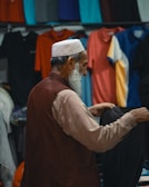 A man sitting in front of a rack of clothing