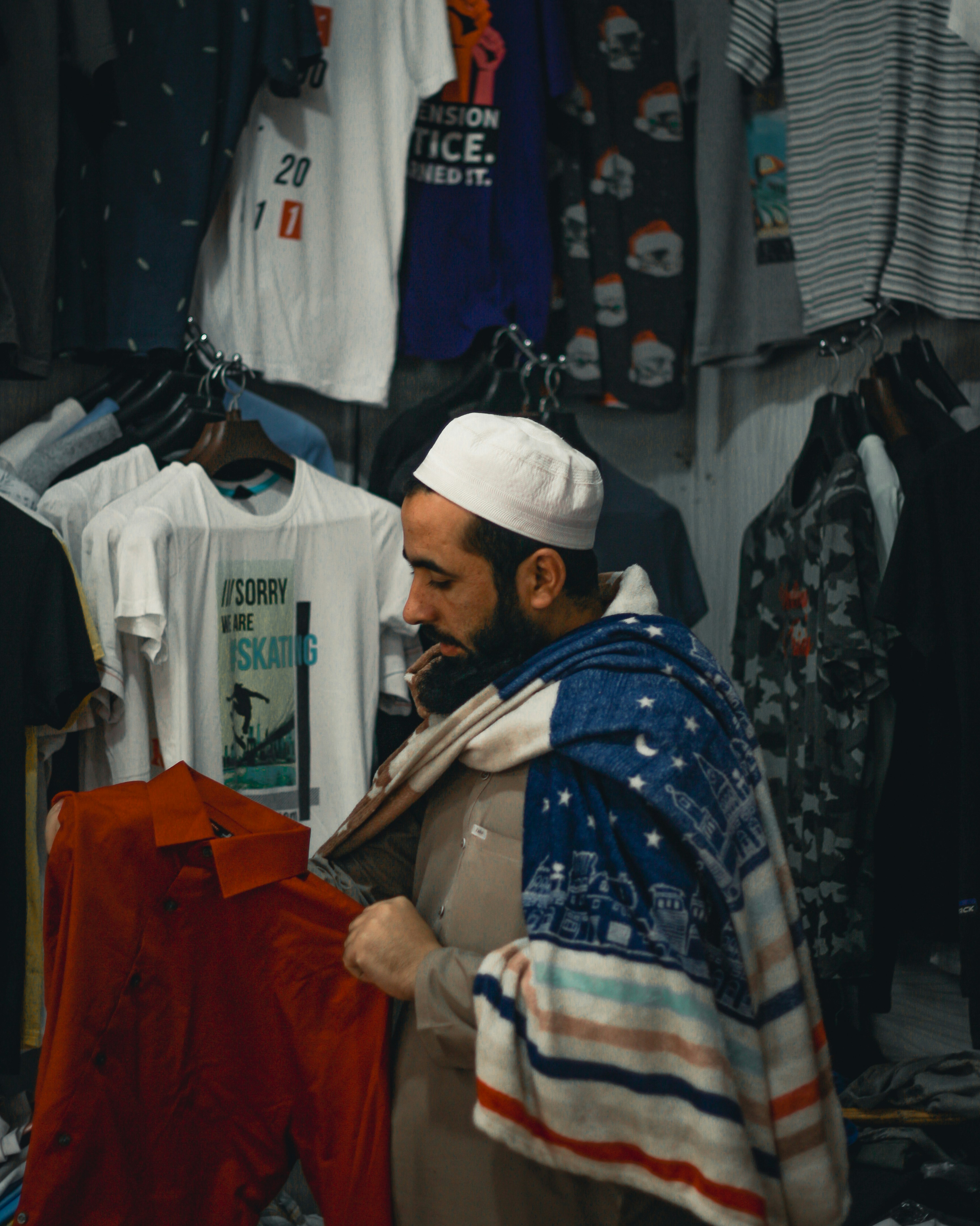 A man standing in front of a rack of shirts
