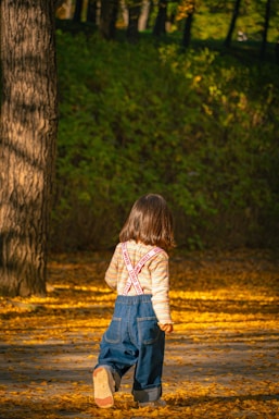 A little girl standing in the woods with a frisbee