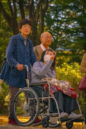 A man in a wheel chair with a woman in a face mask