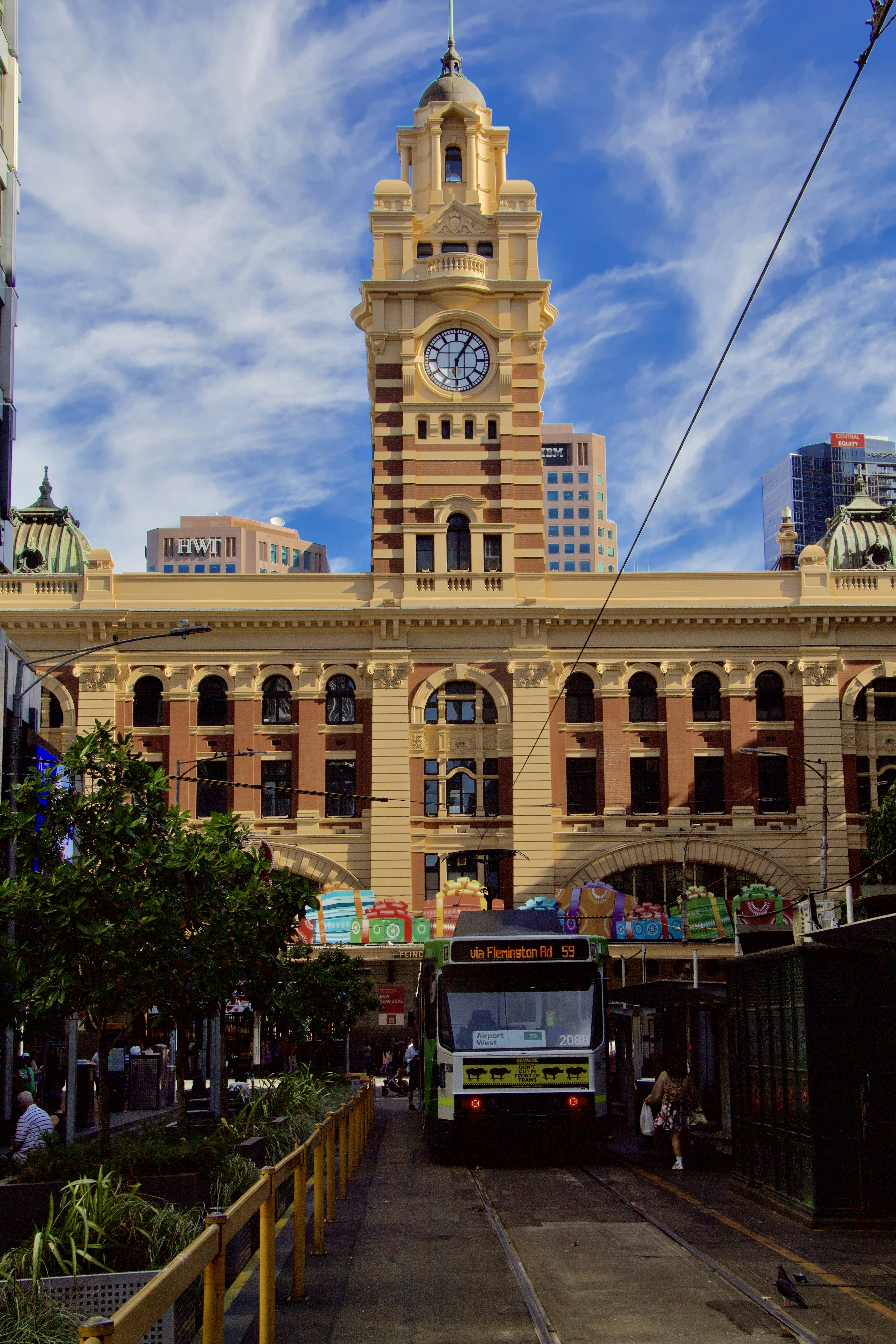 Un autobús que circula por una calle junto a un edificio alto