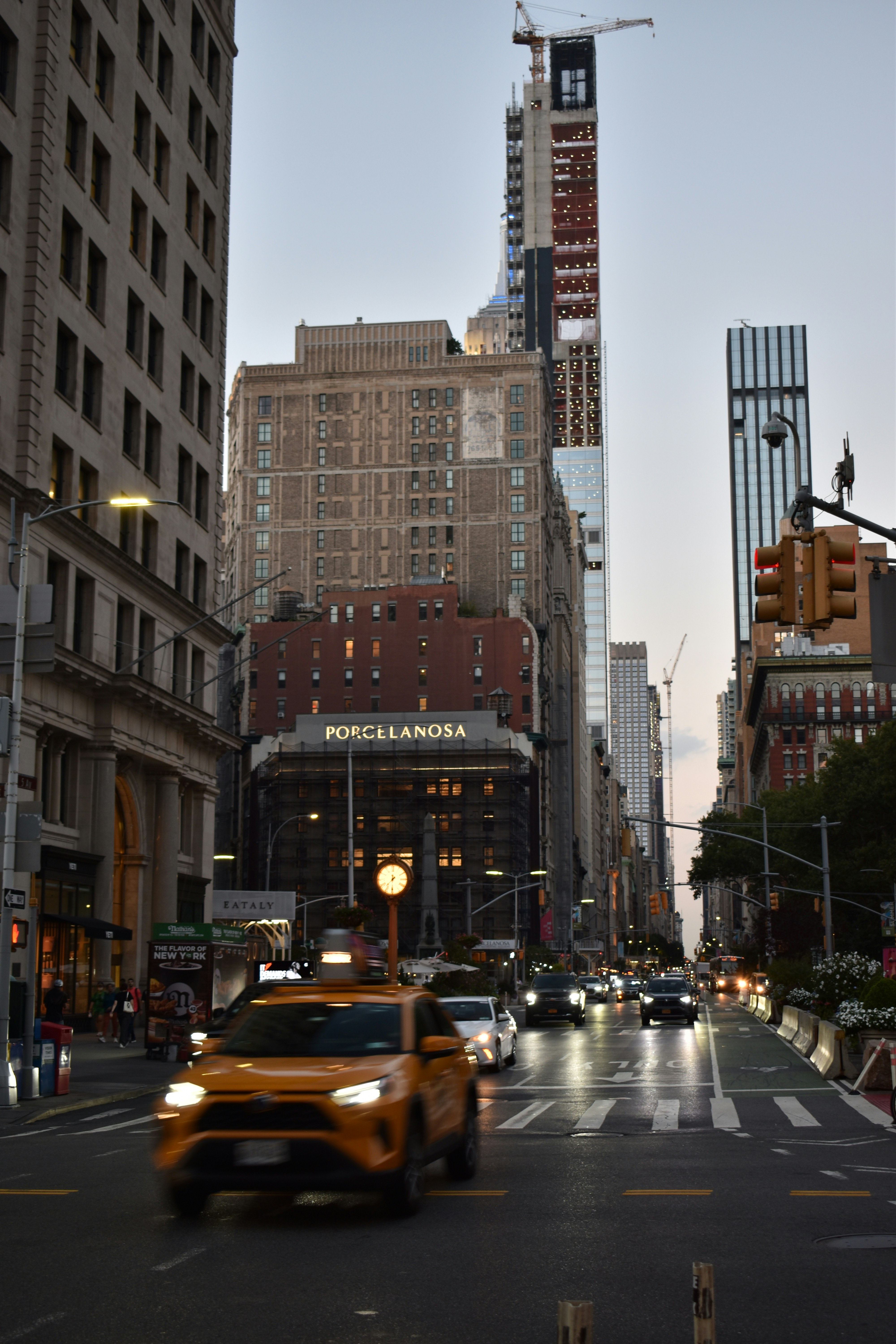 A taxi cab driving down a street next to tall buildings