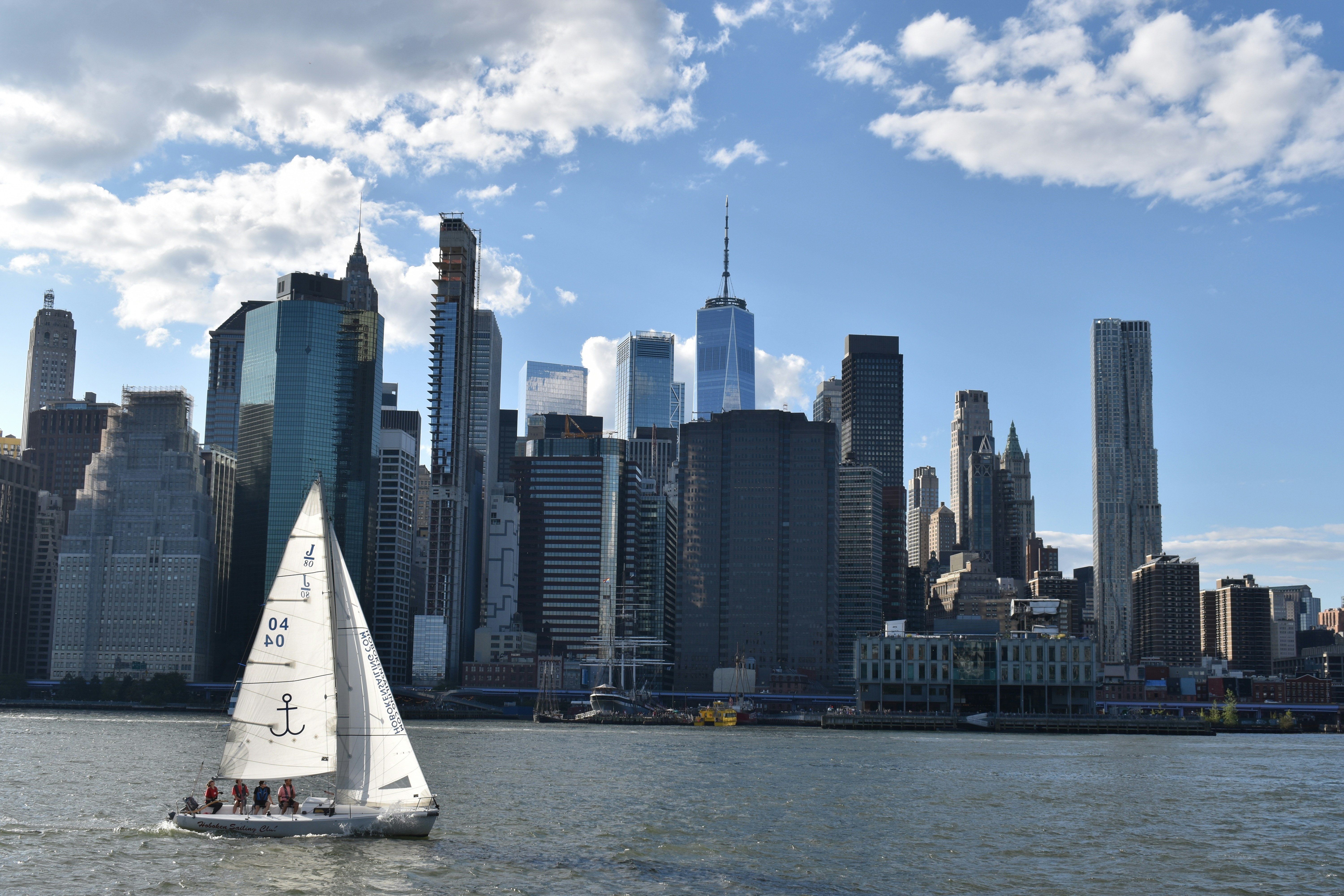 Un voilier passant devant les buildings de Manhattan par une belle journée claire