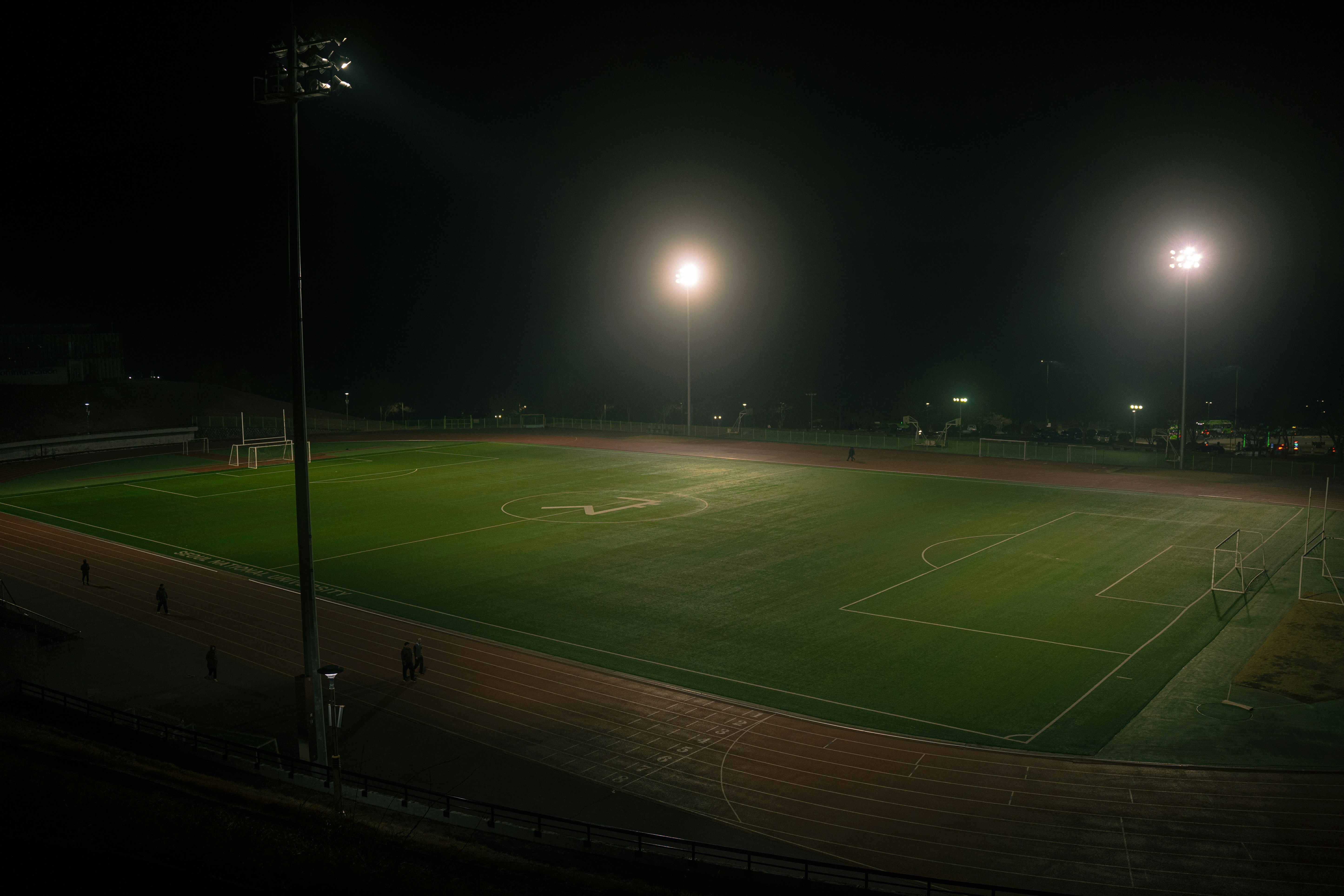 Tribunas encendidas en un estadio europeo durante partido nocturno
