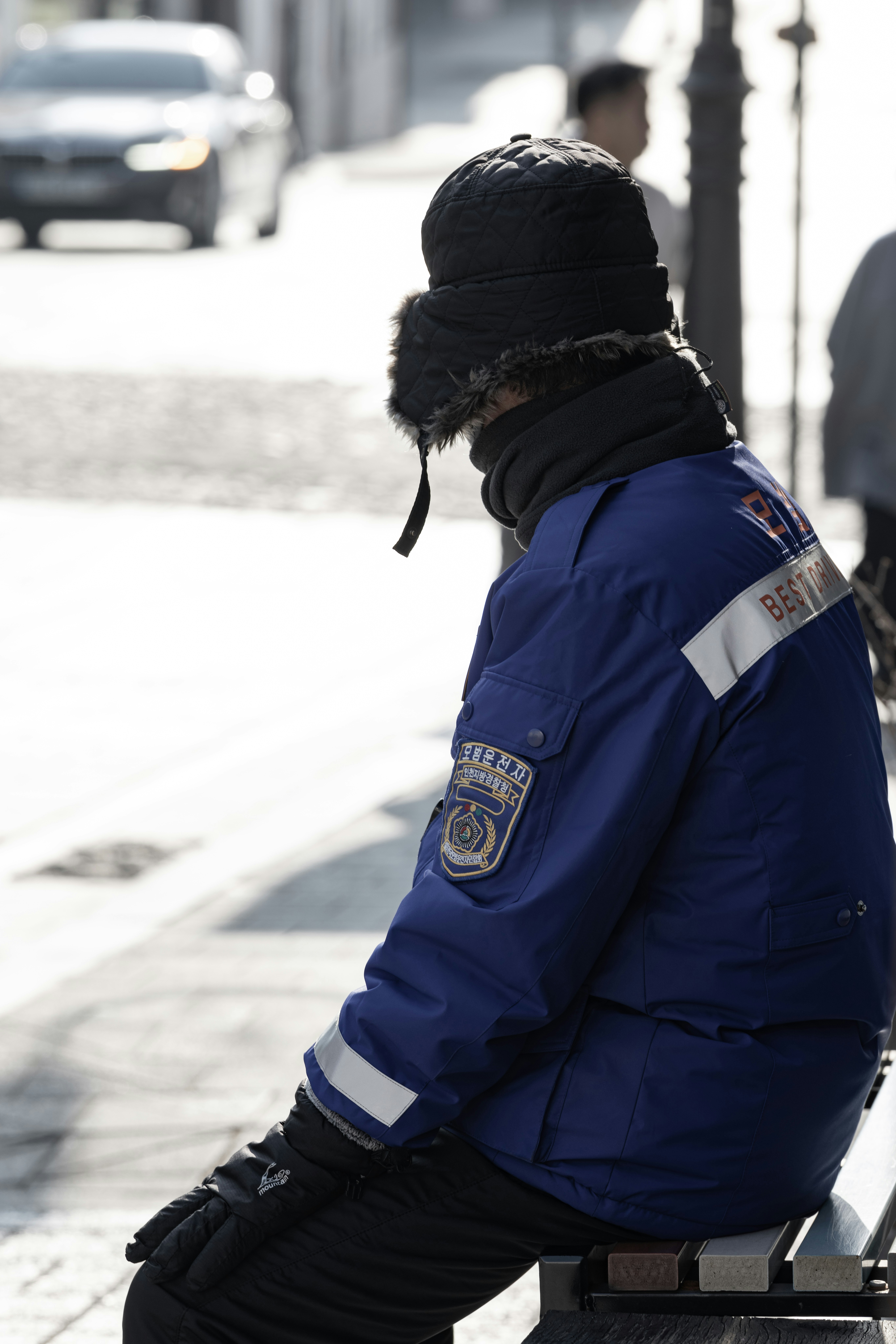 A person sitting on a bench on a city street