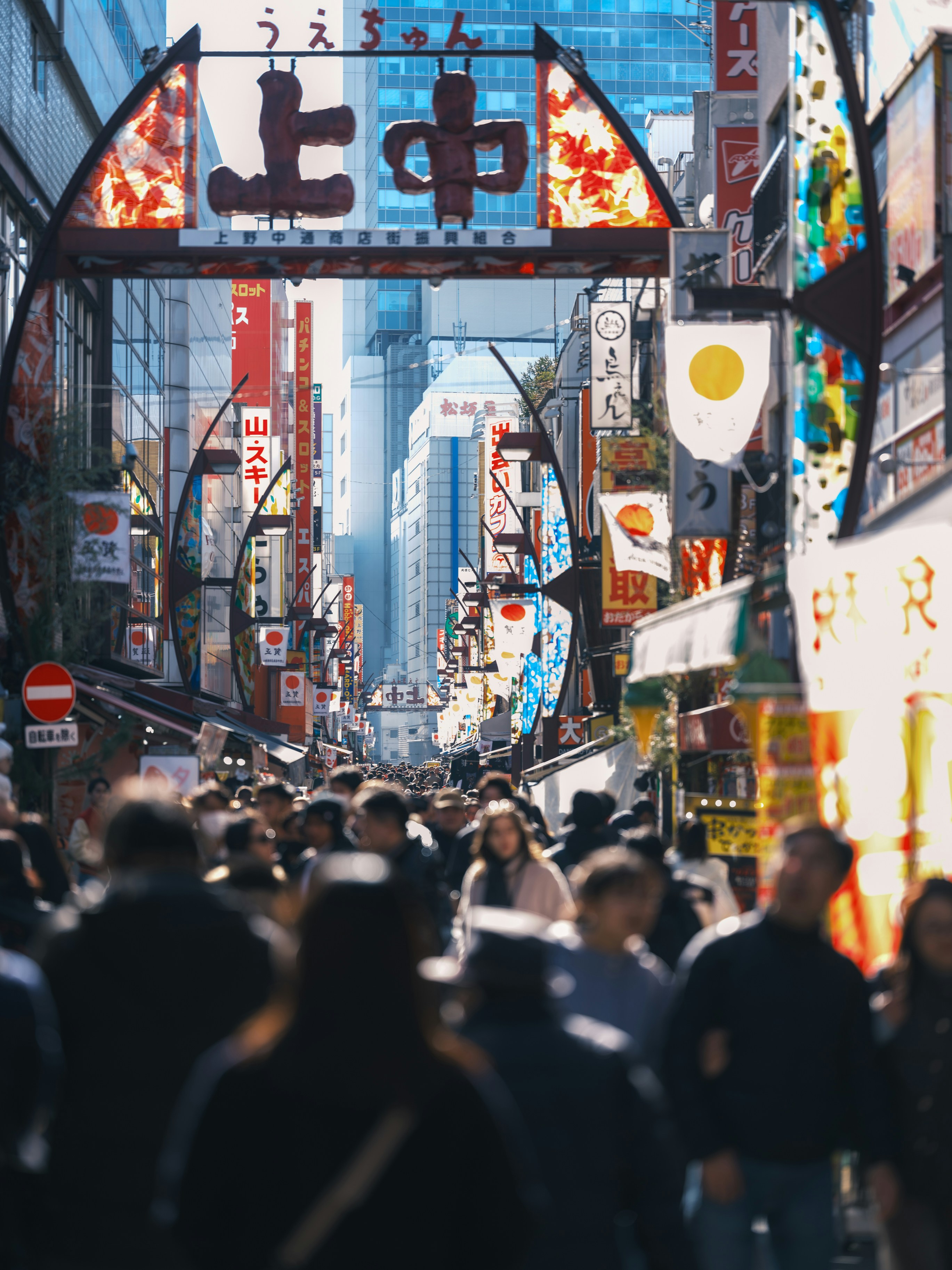A crowd of people walking down a street next to tall buildings