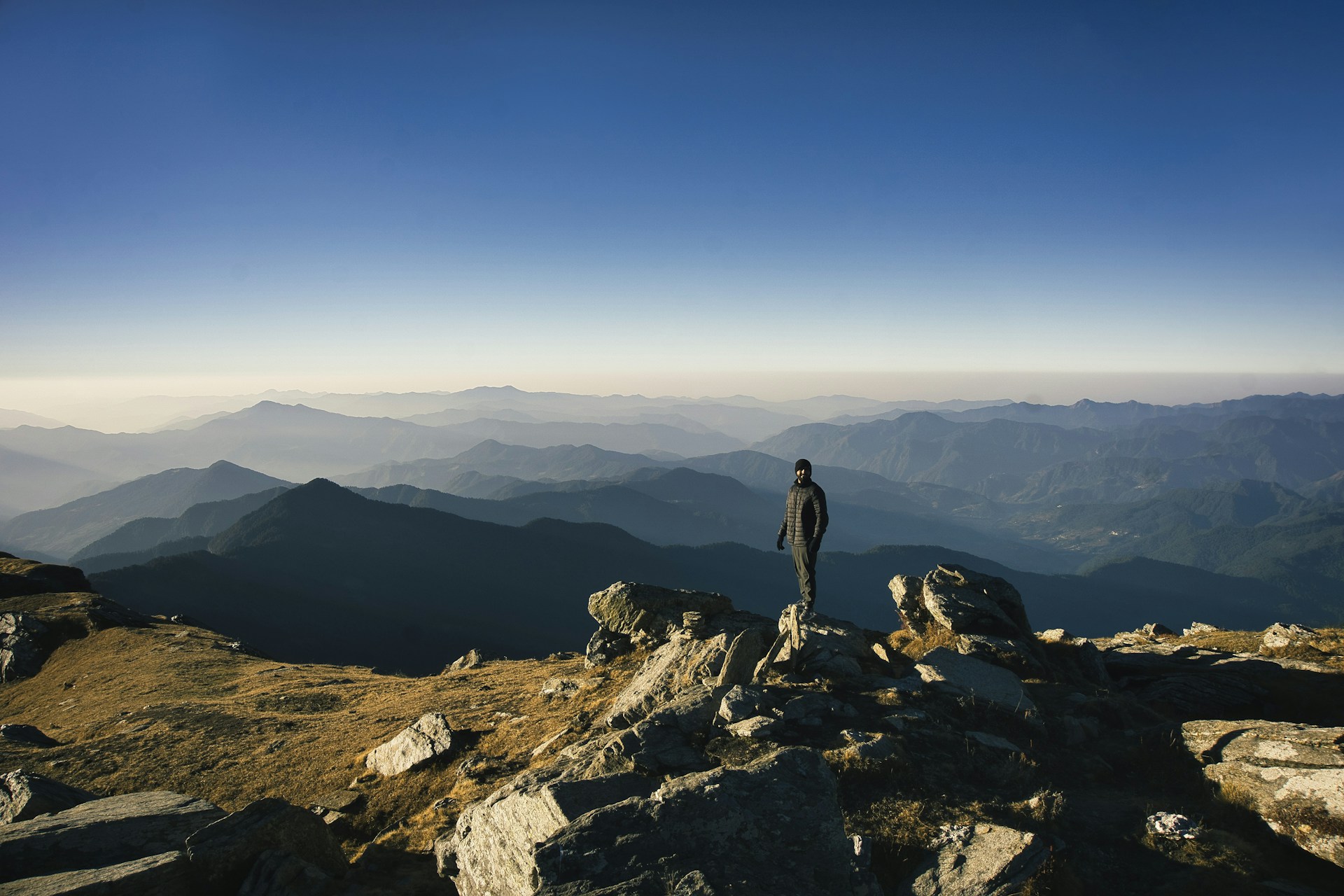 A man standing on top of a rocky mountain