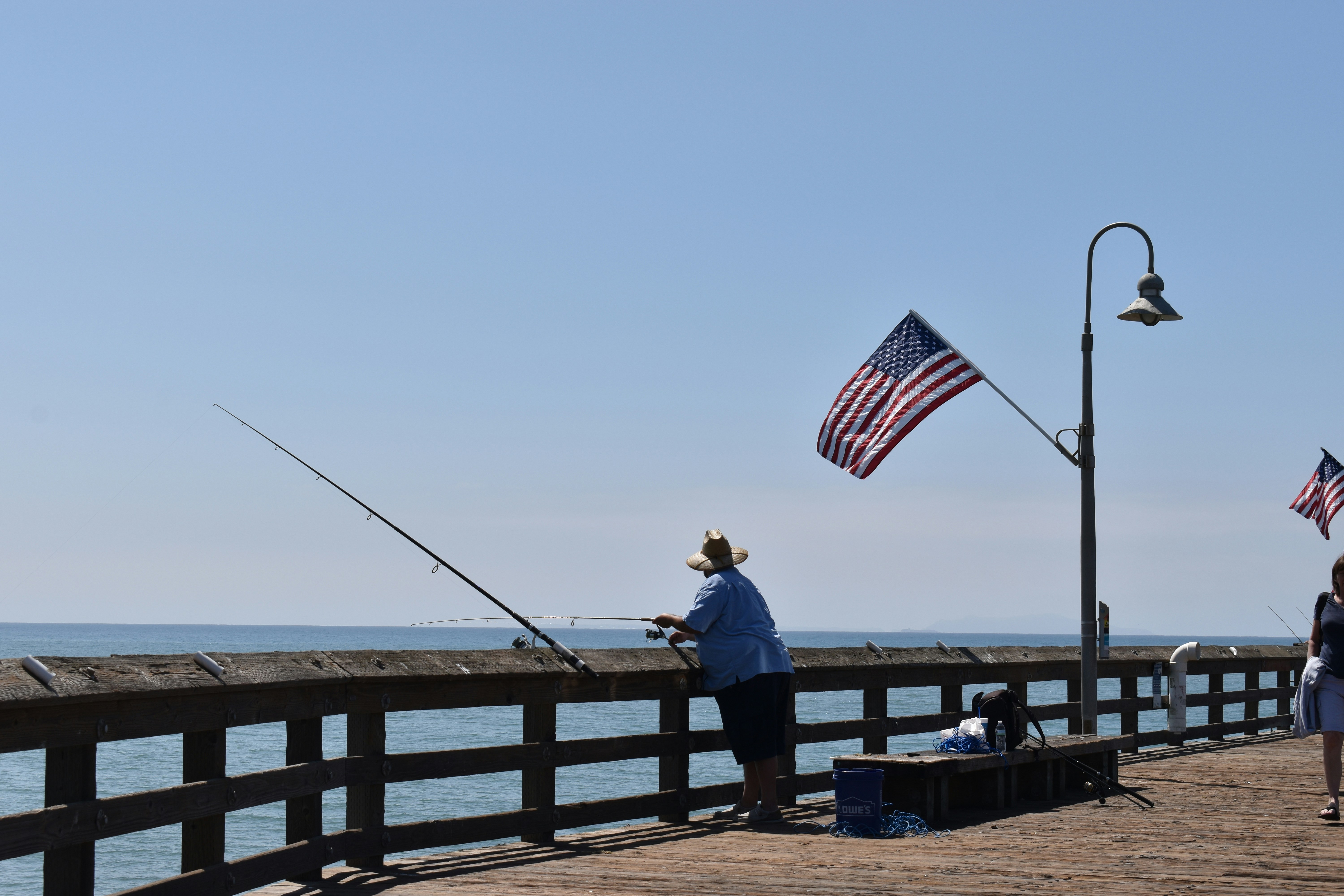 A man and a woman fishing on a pier