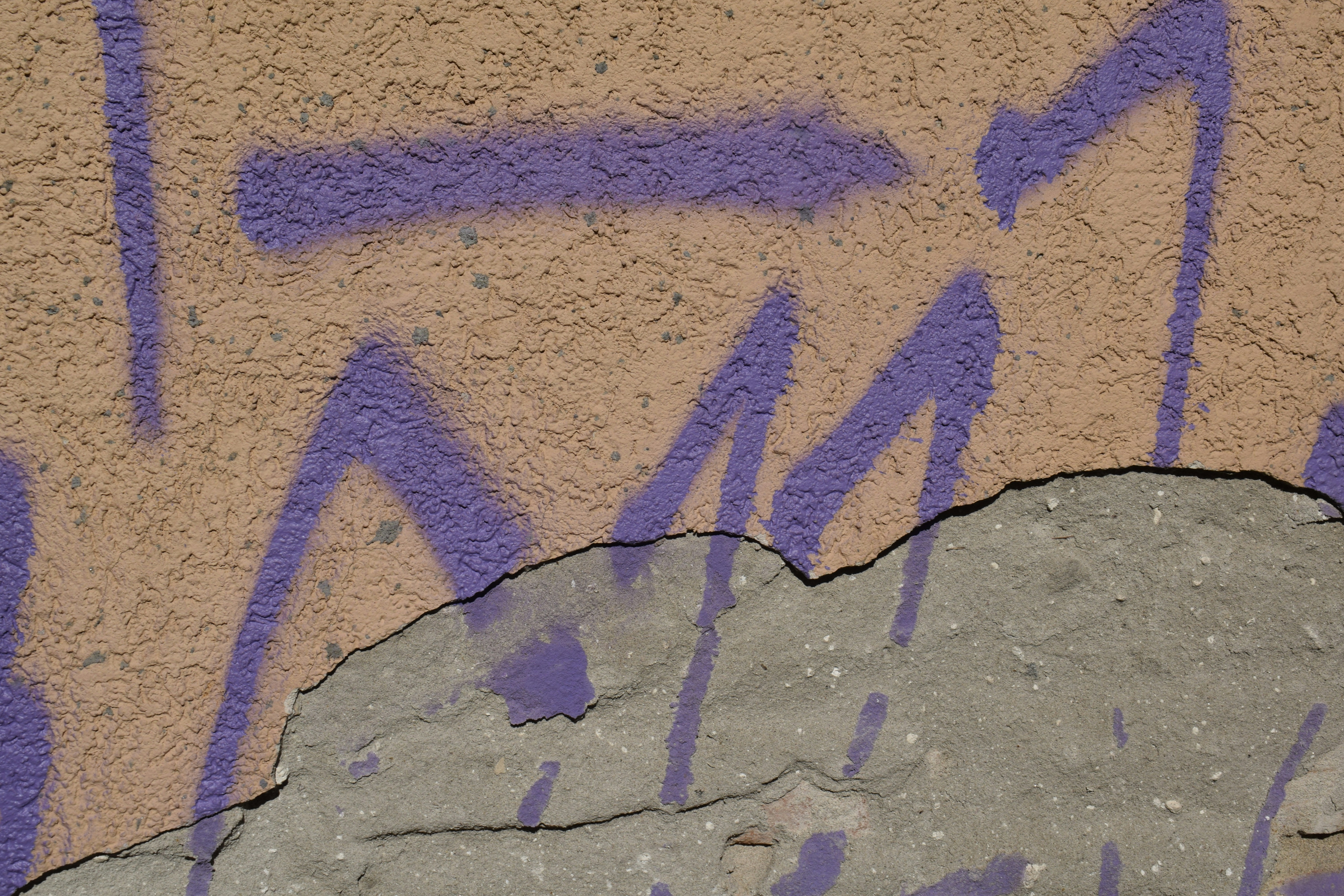 Graffiti on the side of a building near a rock