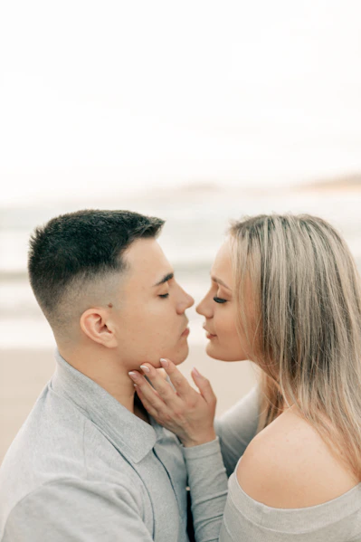 A man and a woman kissing on the beach