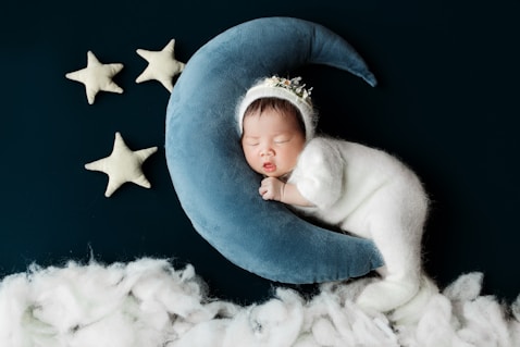 A baby sleeping on top of a blue moon