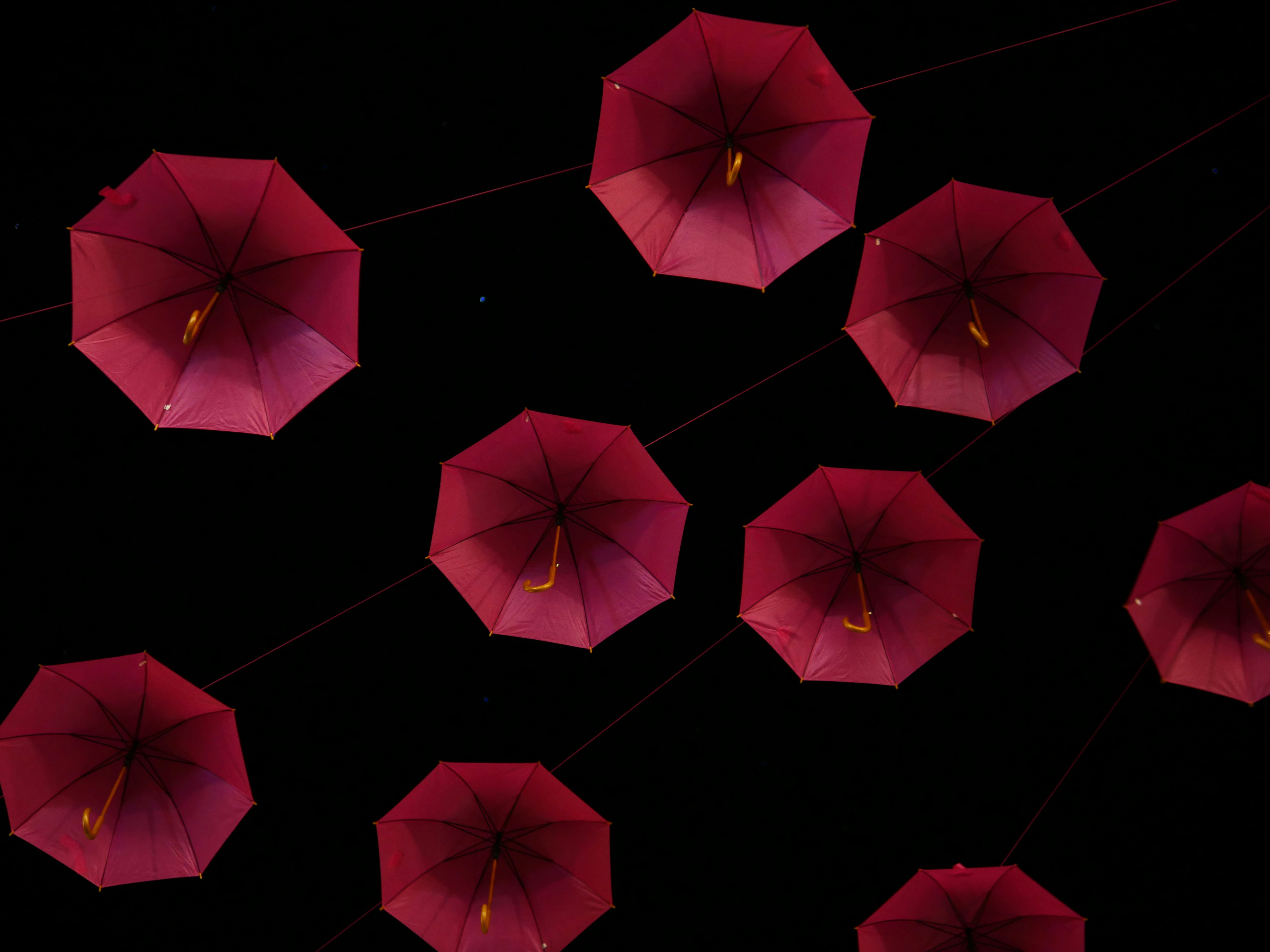 A group of red umbrellas floating in the air