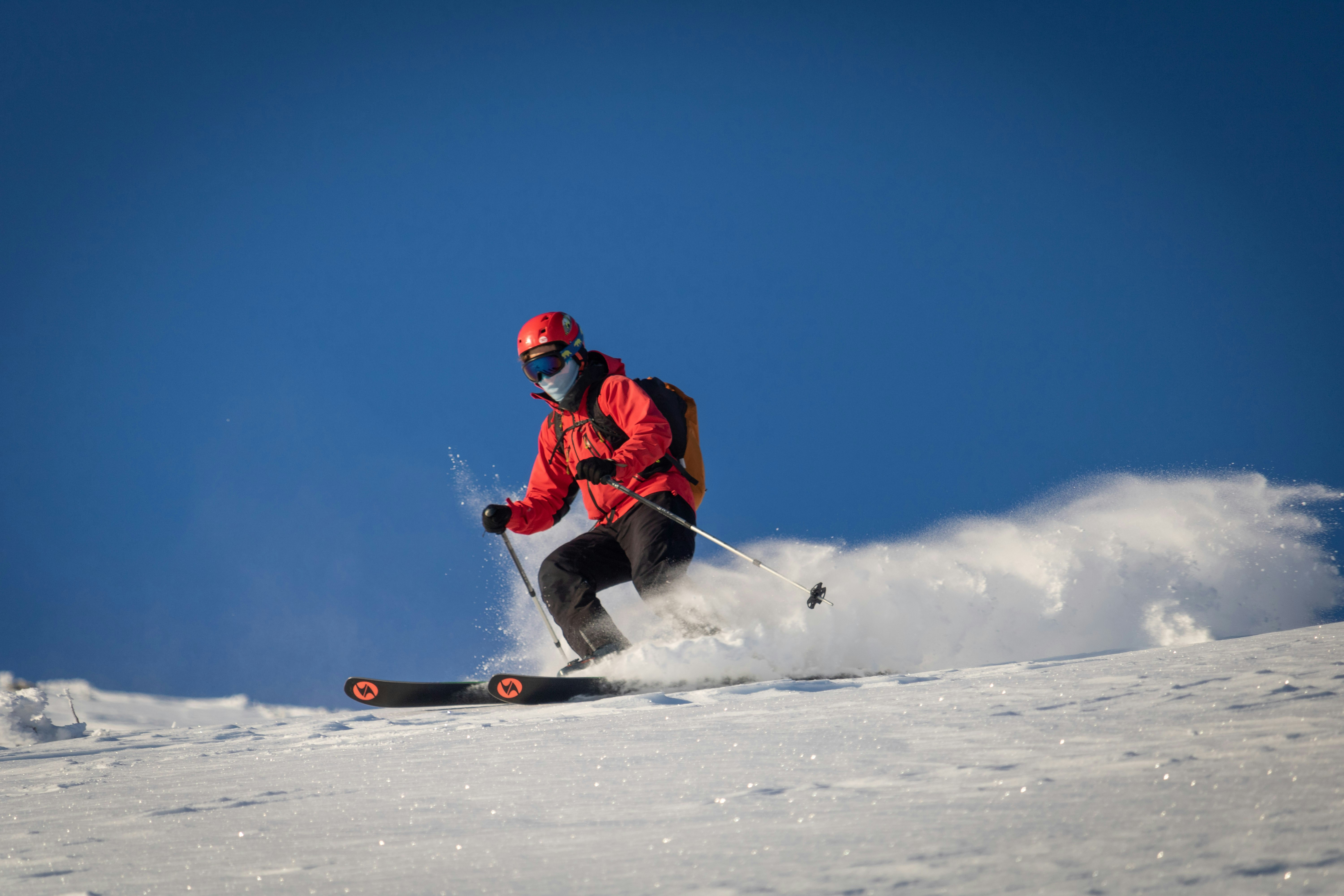 A man riding skis down a snow covered slope, 