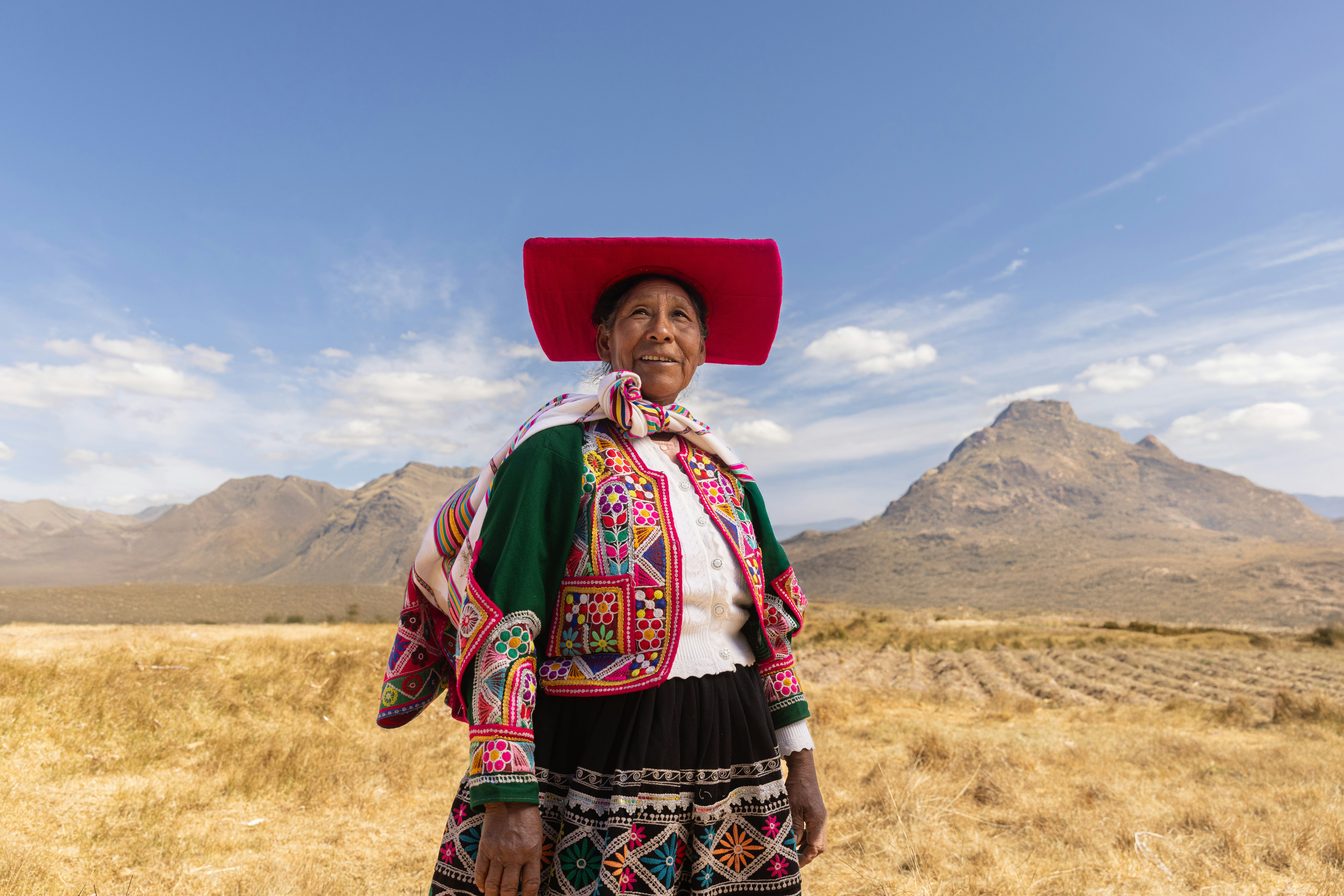 A woman with a red hat standing in a field