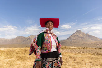 A woman with a red hat standing in a field