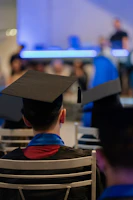 A man in a graduation cap sitting in a chair